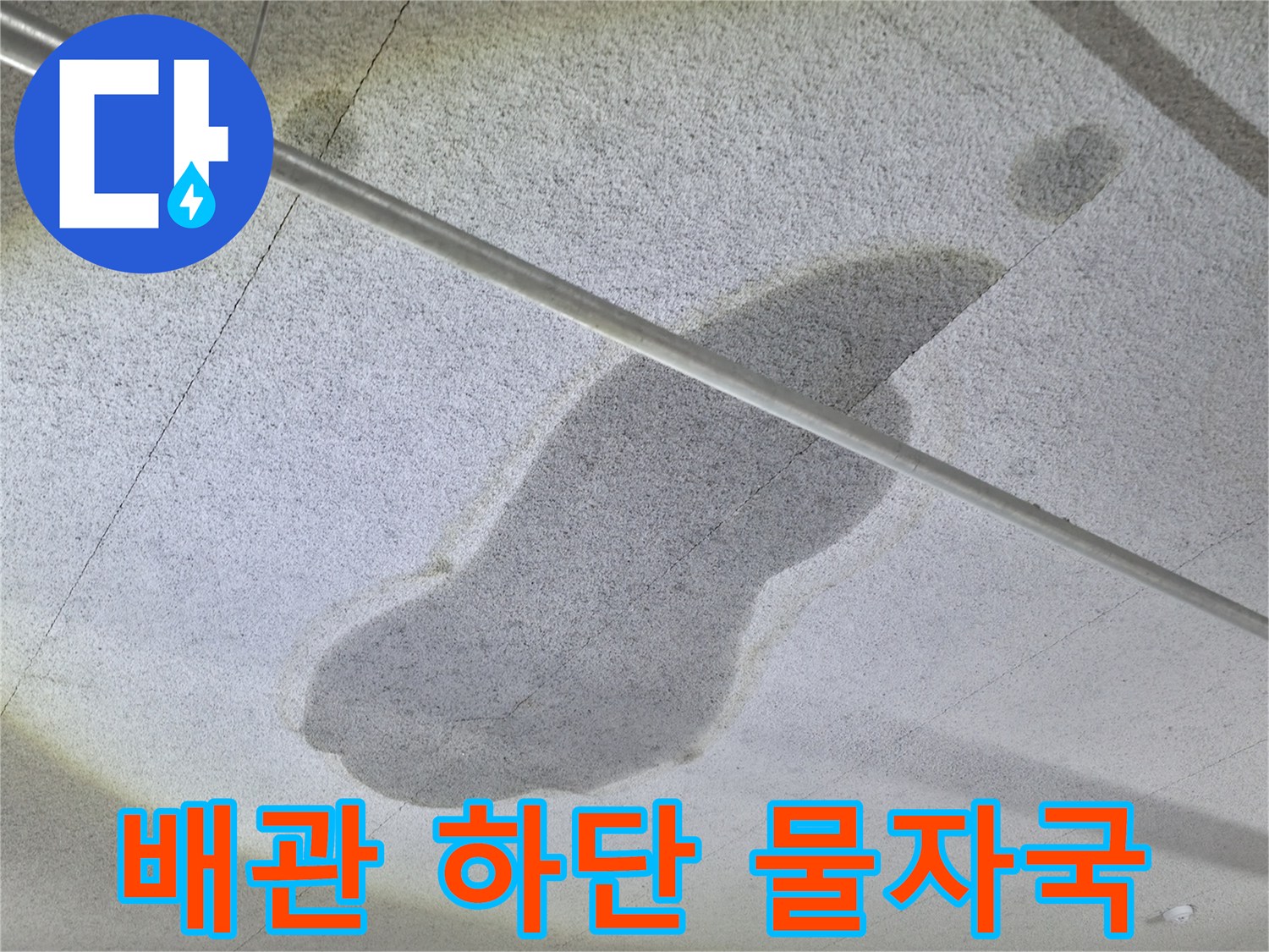 금속 배관 주변에 넓게 퍼진 젖은 콘크리트 면