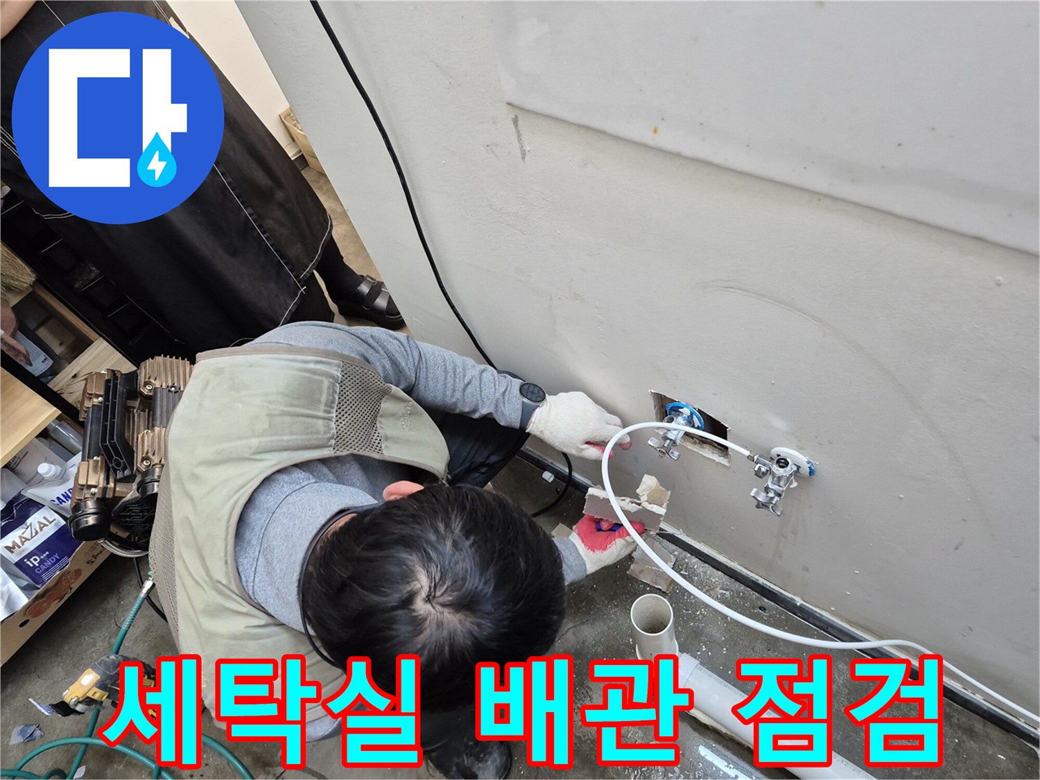 세탁실 벽면 수도 밸브와 연결된 배관을 정밀하게 점검하는 모습