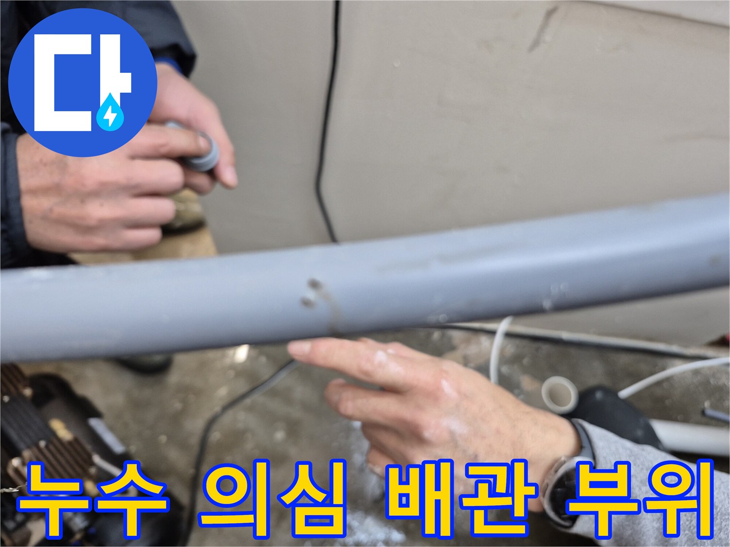 손가락으로 가리키는 배관의 젖은 부분 - 누수 지점 정밀 진단 중