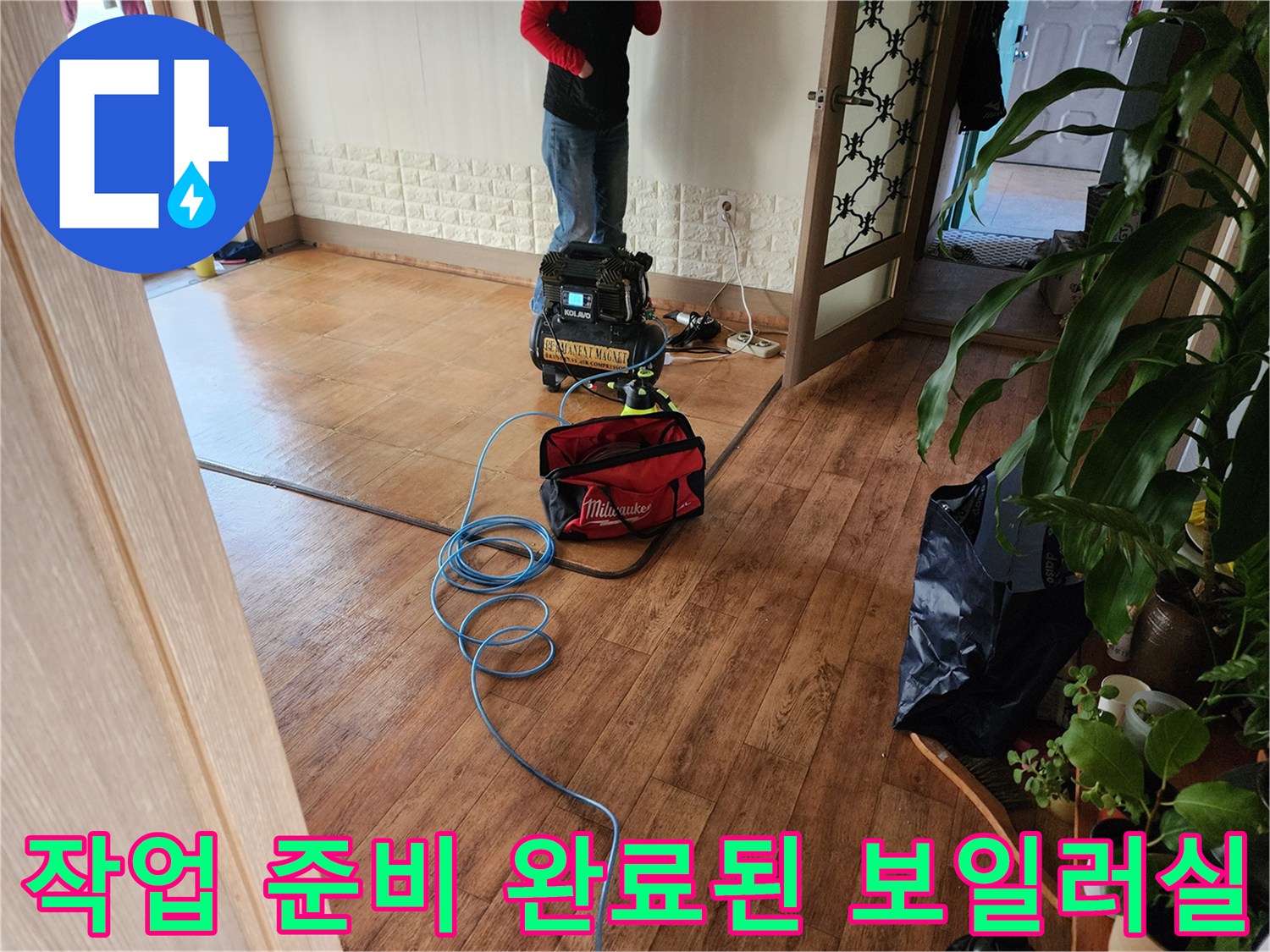 나무 바닥 위에 놓인 작업용 랜턴과 공구함