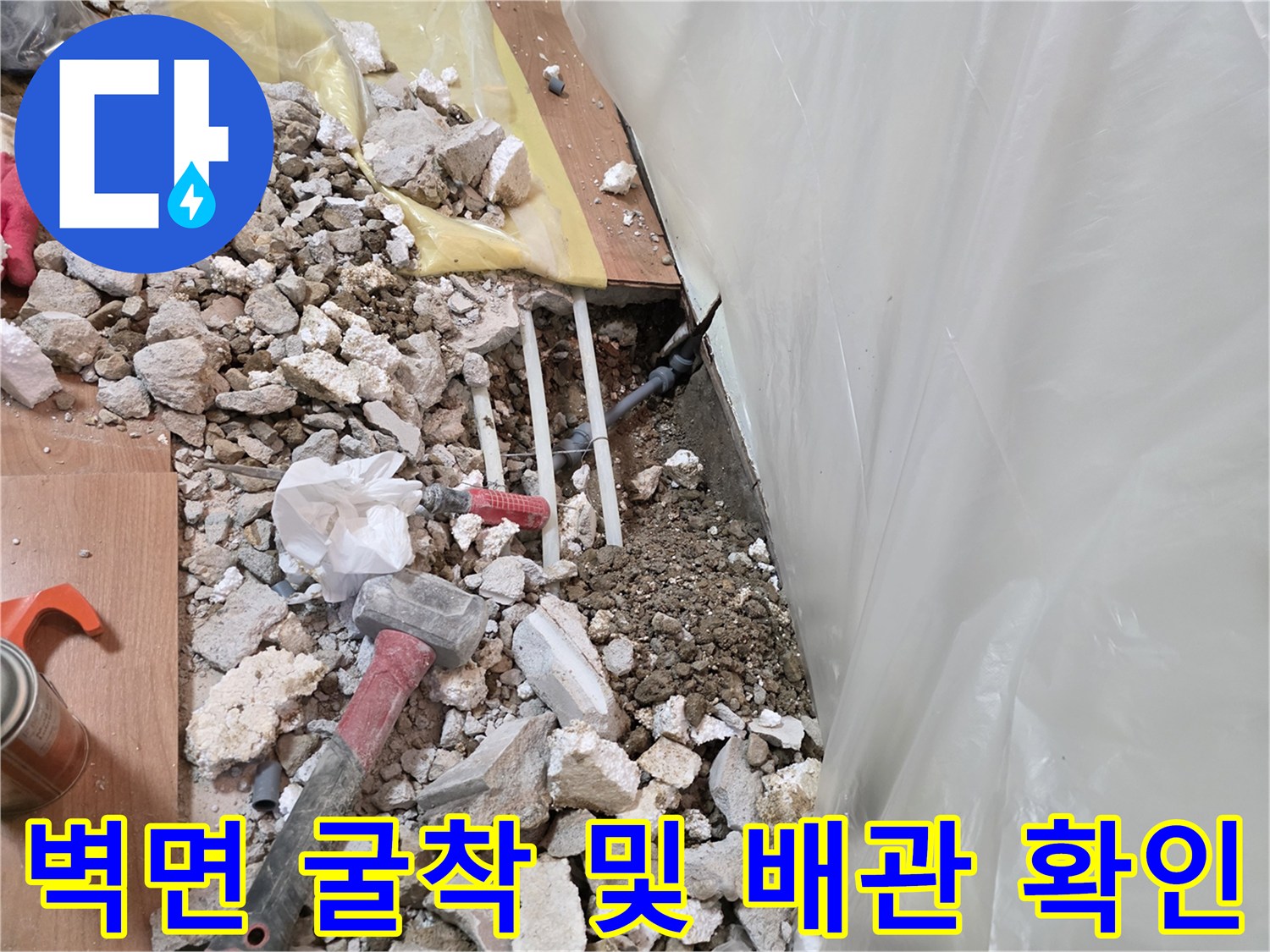 누수 지점 확인을 위해 벽면을 파쇄하고 노출된 배관 상태를 점검하는 모습