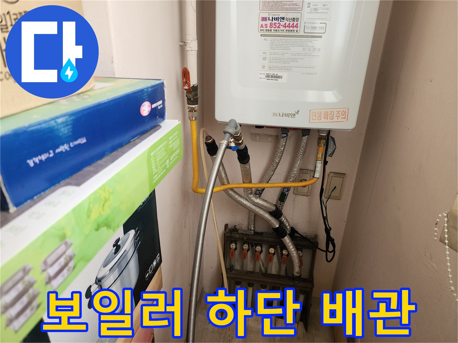 벽면에 설치된 보일러와 연결된 은색 및 금속 배관들