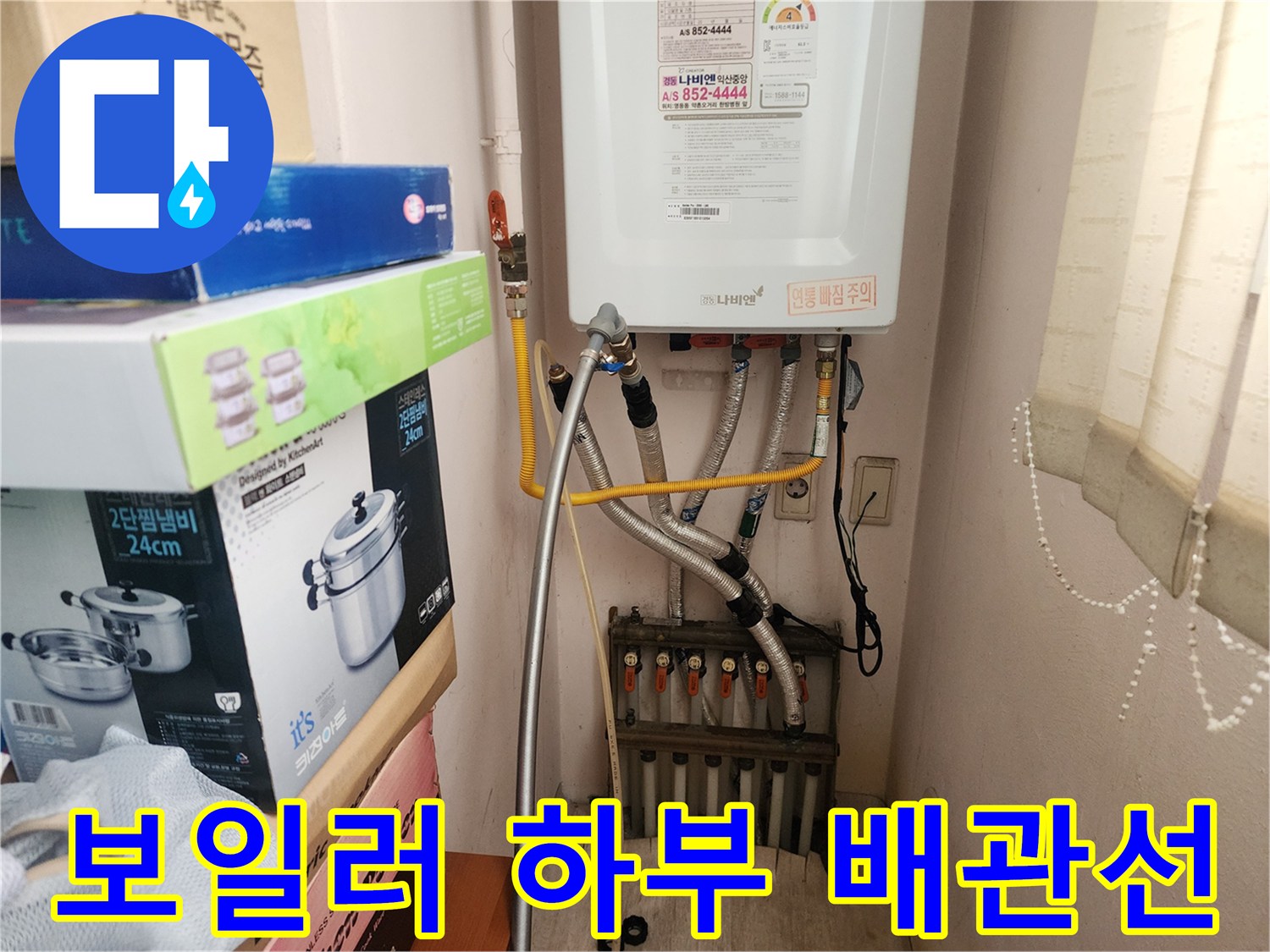 보일러 아래쪽으로 연결된 분배기와 급수 및 온수 배관들