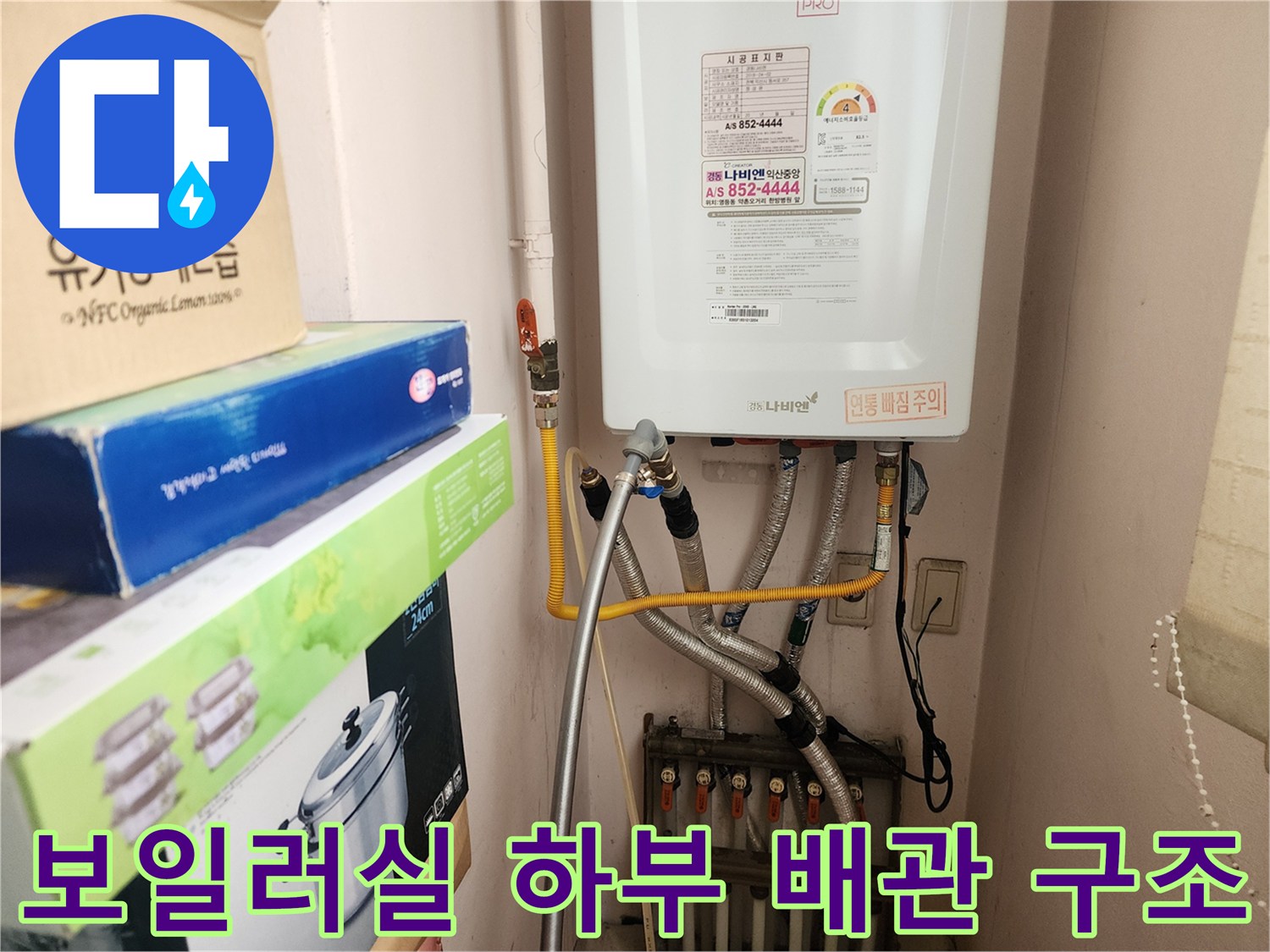하얀색 보일러 본체 아래로 뻗어 나온 은색 자재의 배관들