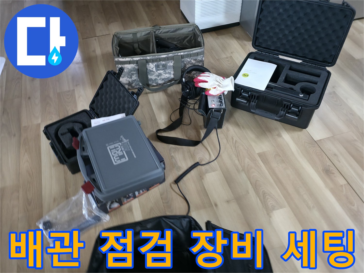 바닥에 놓인 검은색 케이스와 가스 탐지기 및 각종 측정 장비