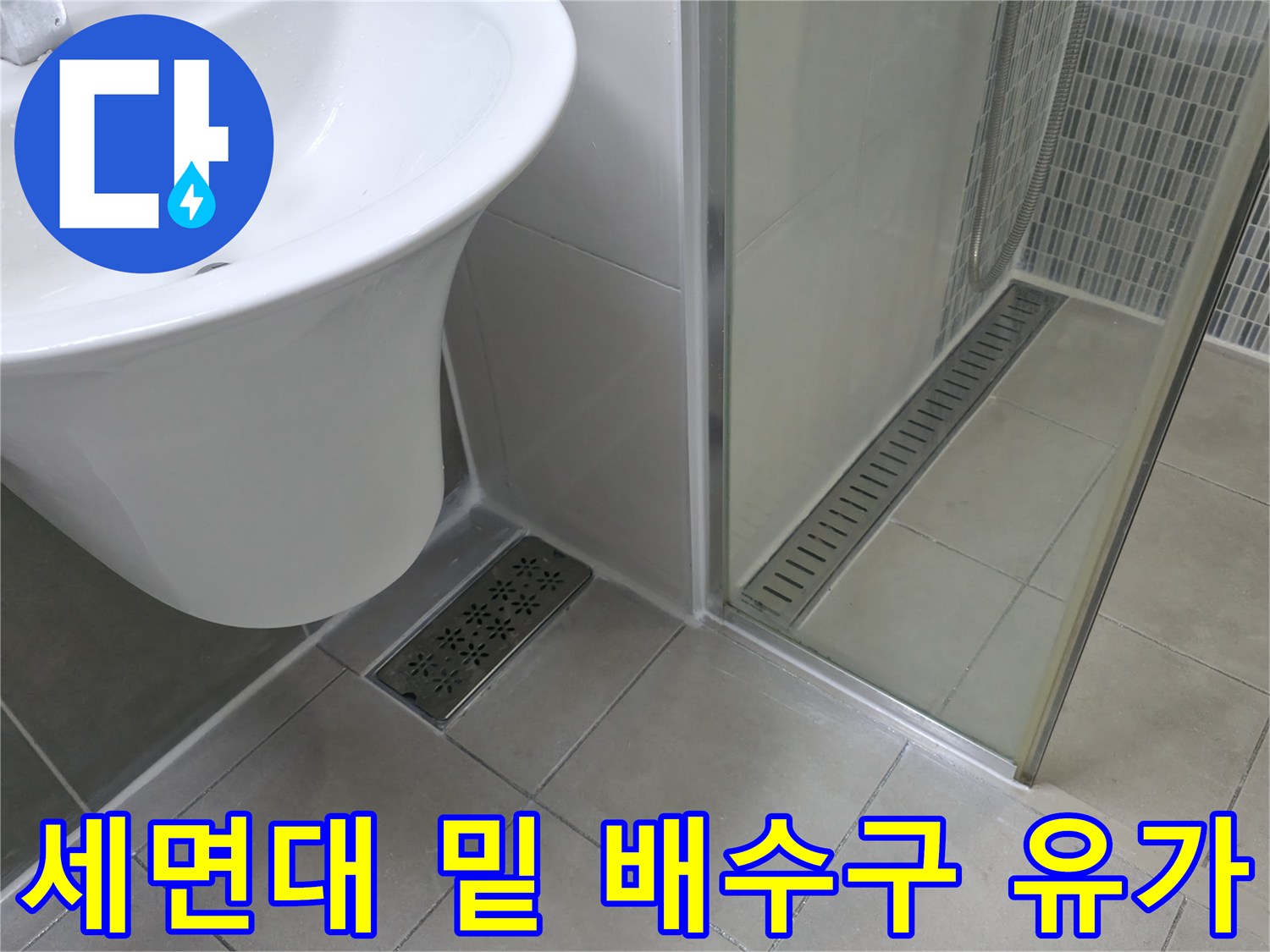 화장실 세면대 아래쪽 바닥 타일과 배수구 근접 촬영