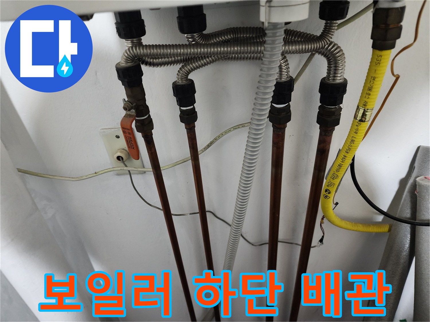 보일러 하단에 연결된 여러 갈래의 동배관과 주름관 모습