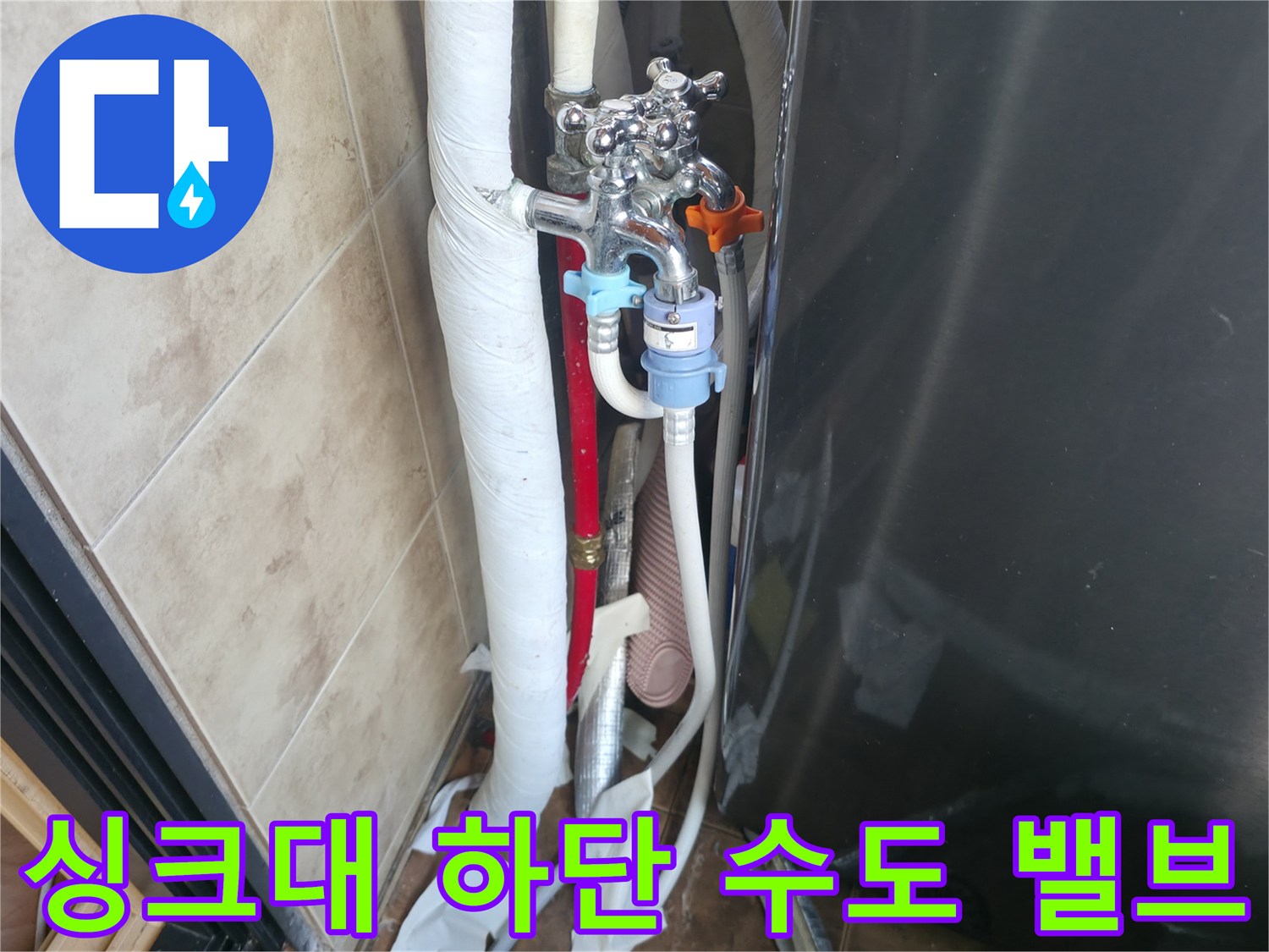 주방 싱크대 아래쪽의 수전 밸브와 연결된 배관 모습