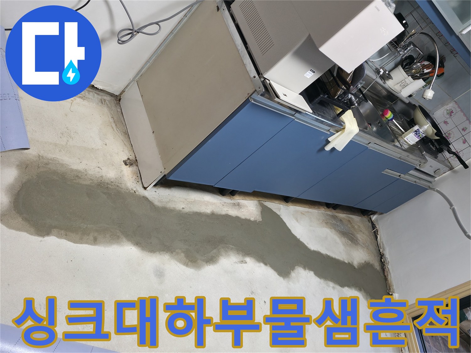 주방 싱크대 하단 바닥의 젖은 자국과 작업 중인 공간