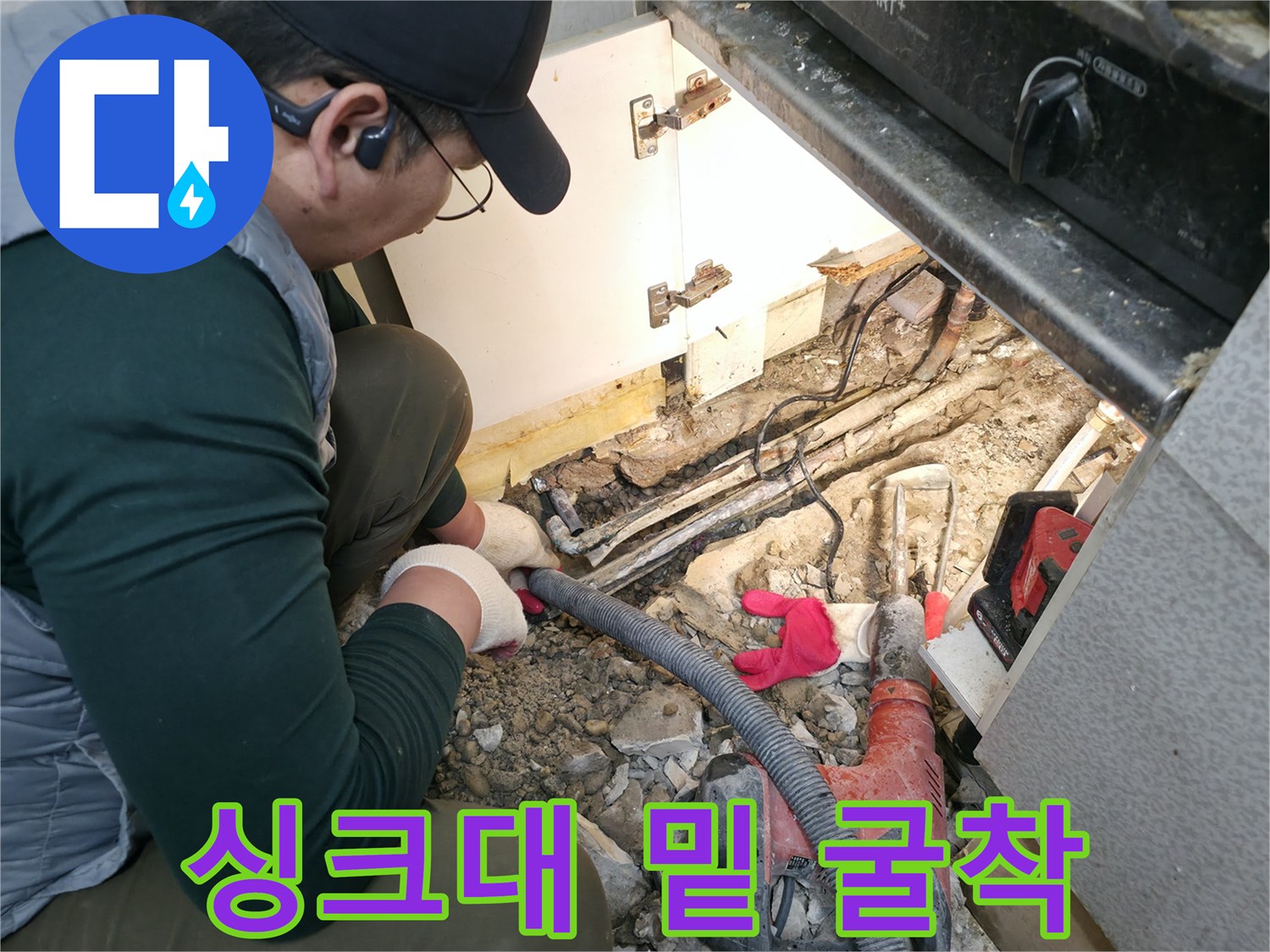 공사 중인 싱크대 하단-드러난 바닥 배관과 작업 도구