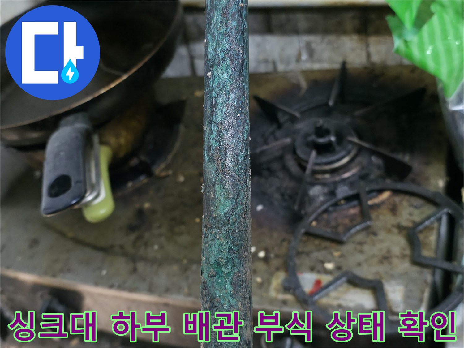 심하게 녹슬고 변색된 배관의 연결 지점을 근접 촬영한 사진입니다.