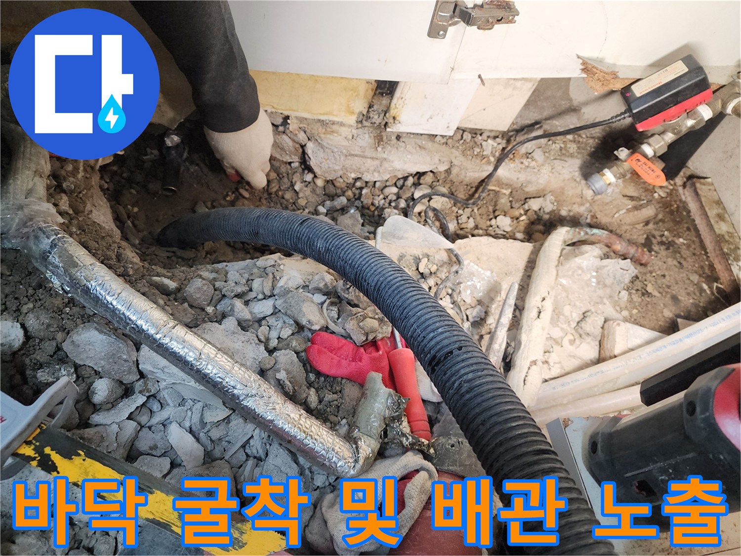 콘크리트 파편과 함께 드러난 매립된 누수 의심 배관 부위