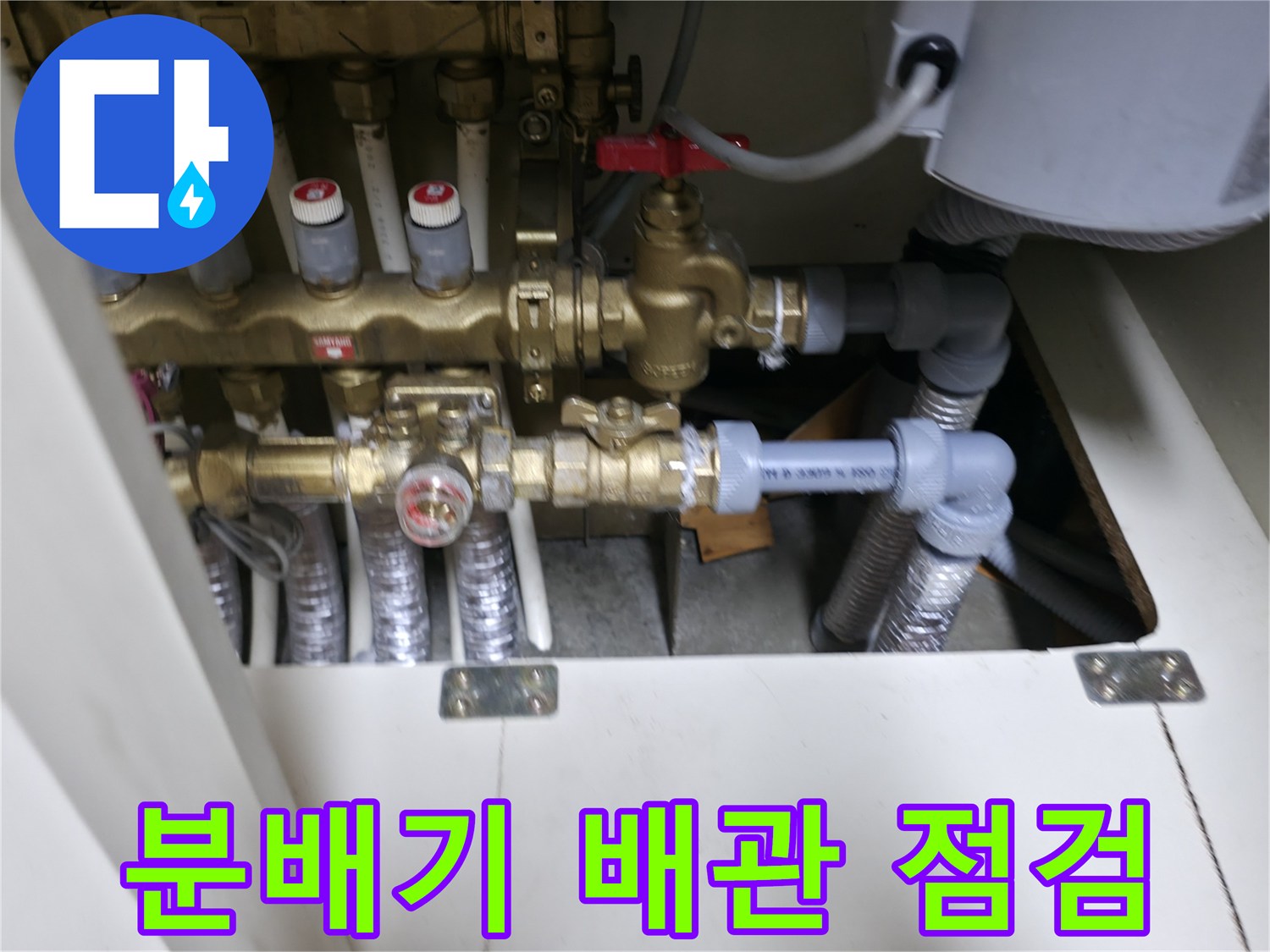 신발장 내부의 온수 분배기와 연결된 배관 상태를 확인하는 모습
