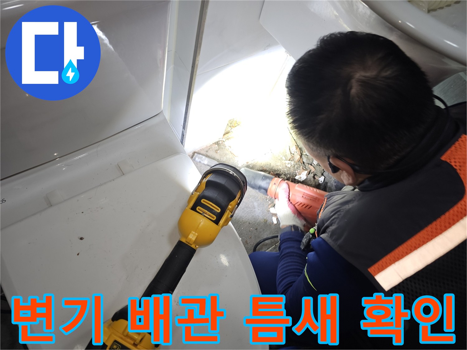 좁은 변기 뒷 공간에서 조명을 이용해 누수 부위를 찾는 모습