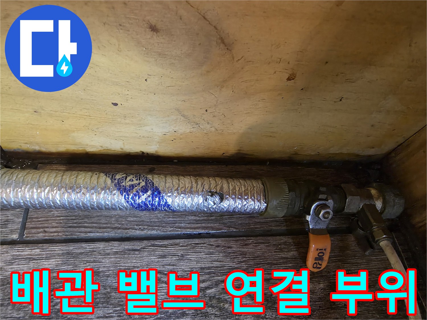 배관의 금속 부속과 주황색 조절 밸브가 맞물린 부분