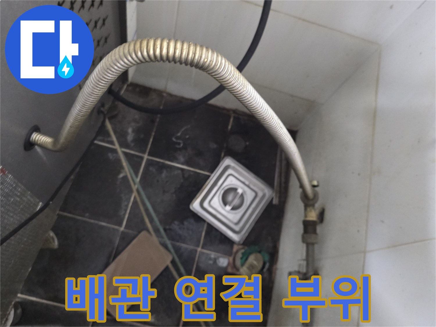 온수기 하단 금속 배관과 바닥 타일의 노후 상태