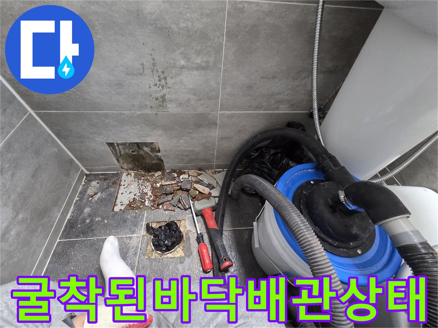 타일을 제거하고 드러난 흙과 부서진 콘크리트 사이의 배관 파손 부위