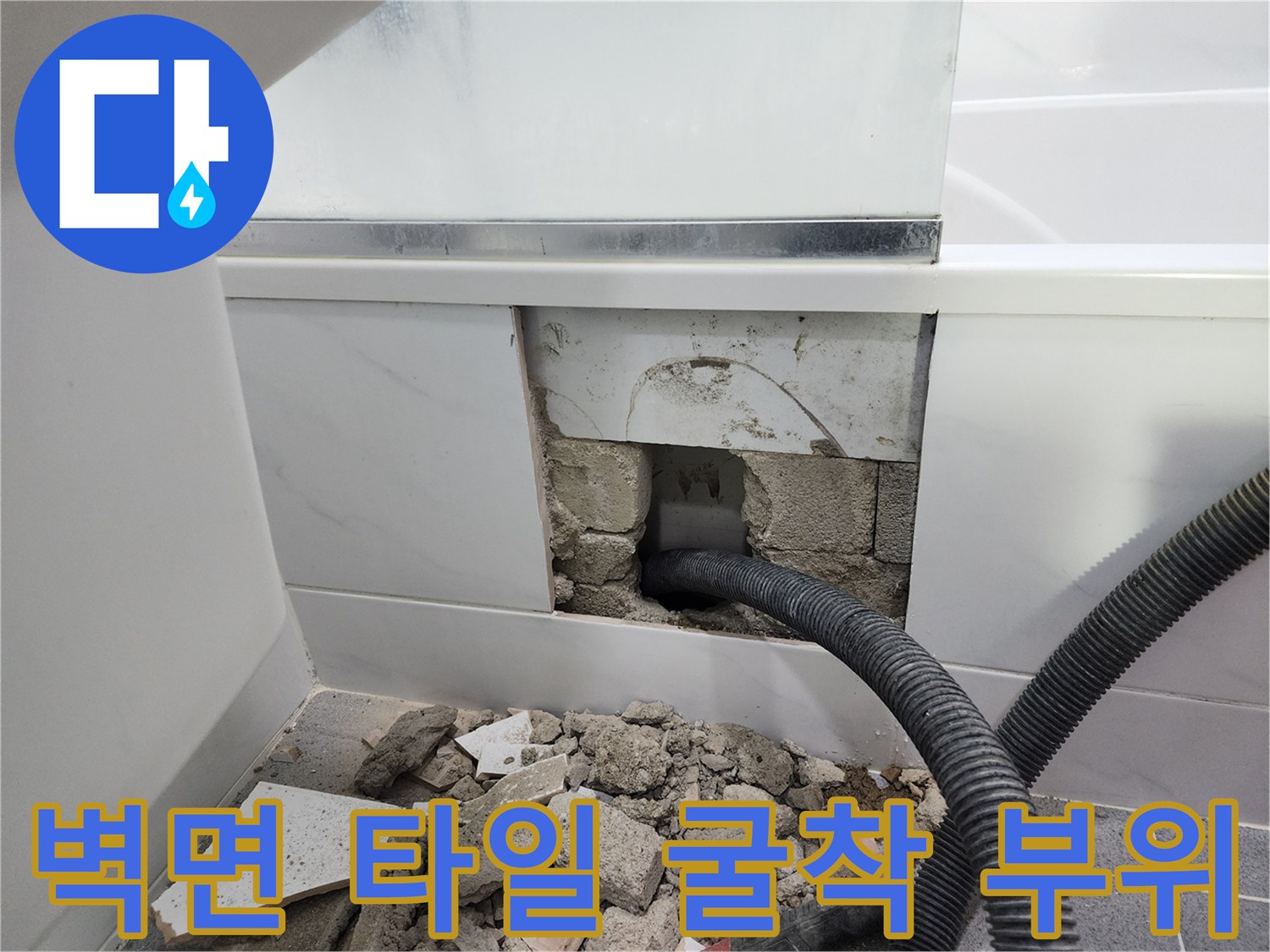 타일을 깨고 드러난 벽체 내부의 파손된 배관과 잔해물