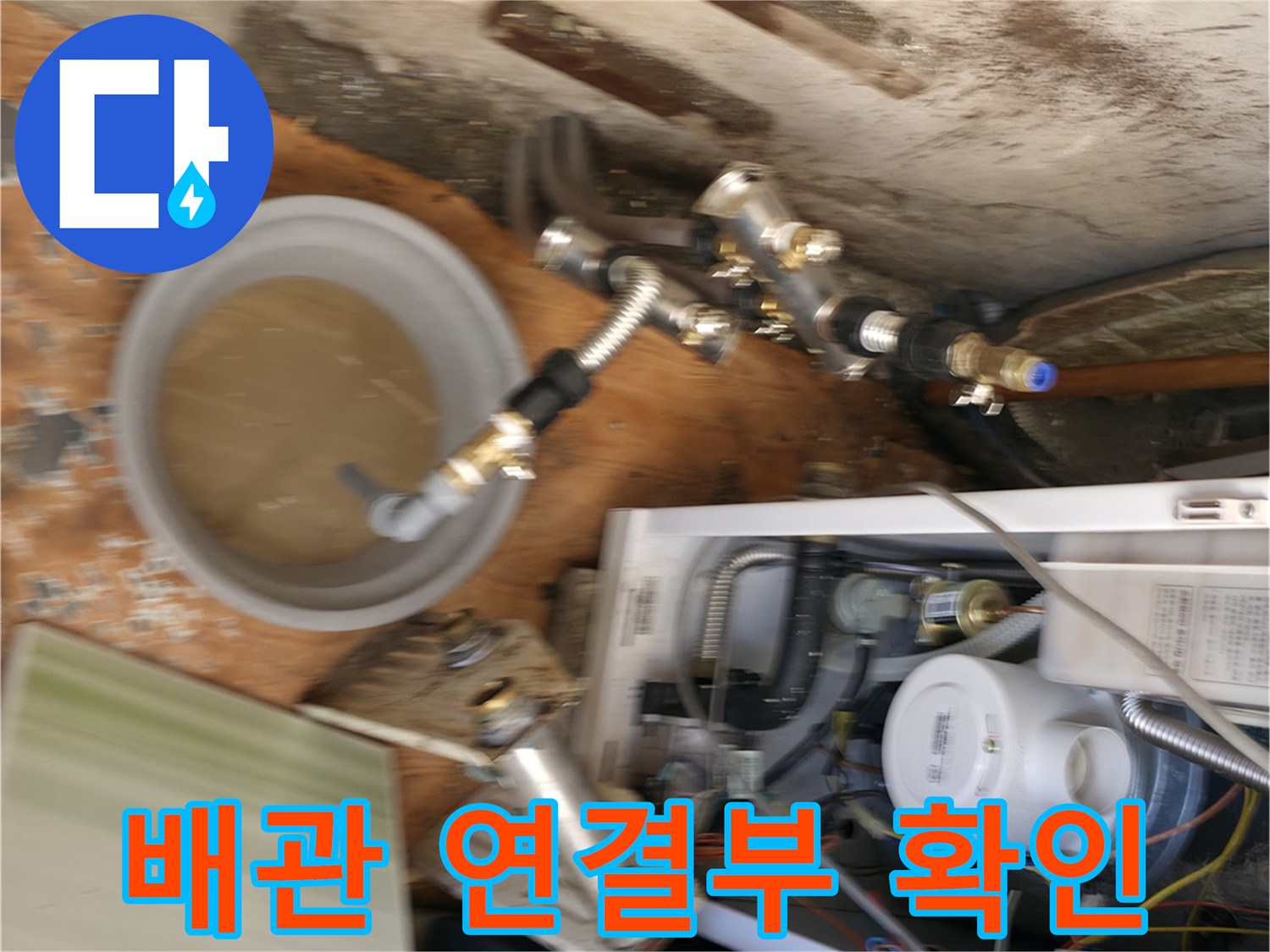 보일러 배관 부속과 물이 담긴 대야를 촬영한 사진