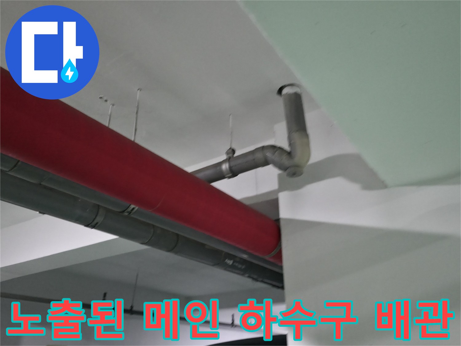 붉은색 벽면과 회색 파이프라인의 연결 부위 촬영
