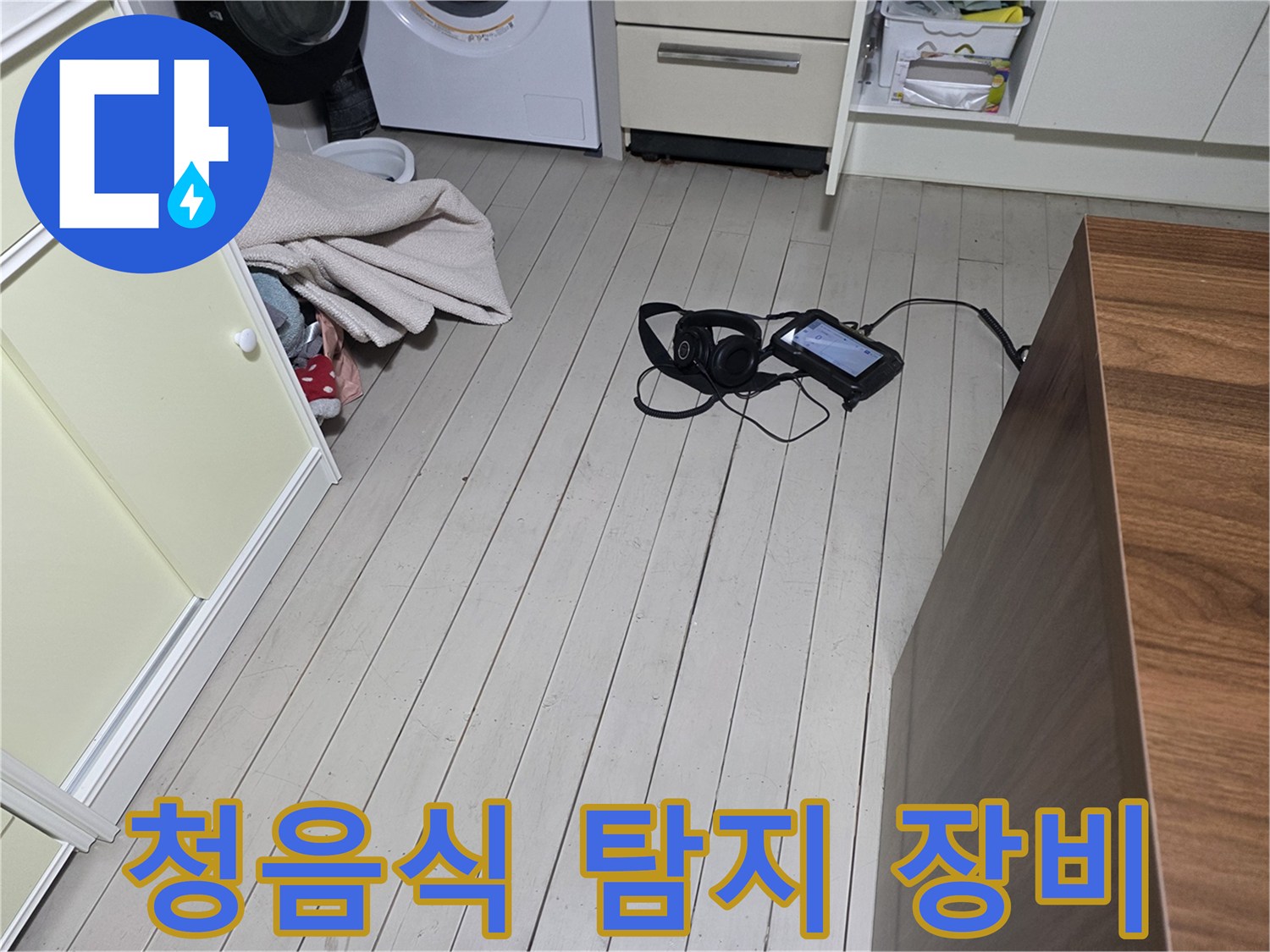 바닥에 놓인 청음식-누수 탐지 헤드셋과 디지털 측정 기기