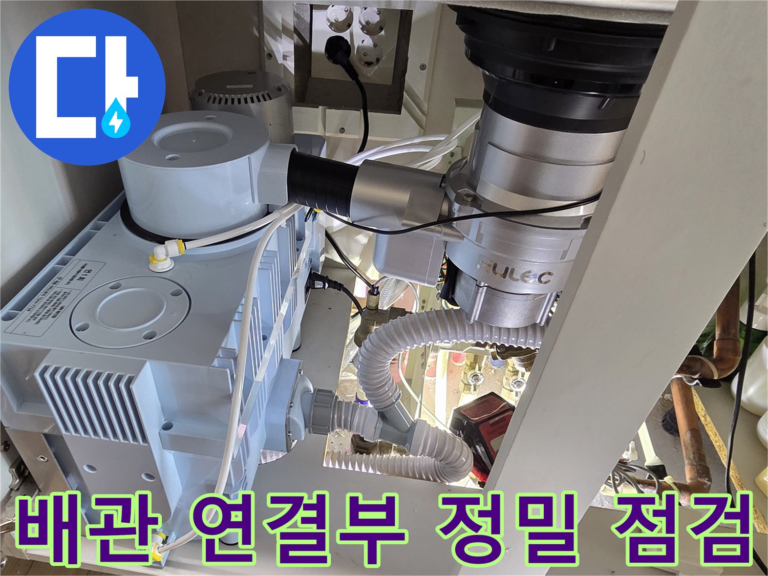 싱크대 아래 설치된 배수 호스와 압력계 장치 구성