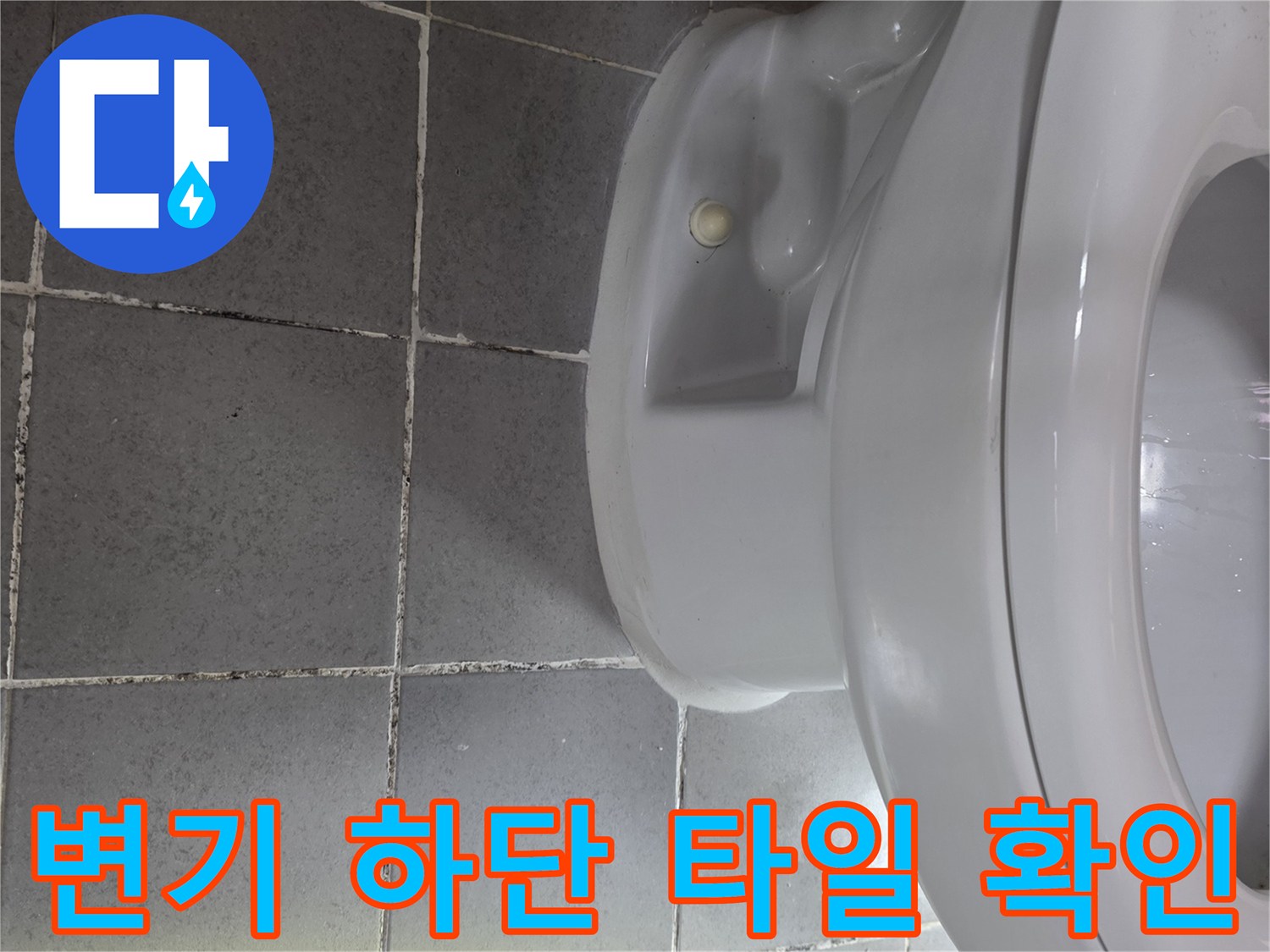 변기 아래쪽 바닥 타일과 배관 연결 부위 근접 촬영