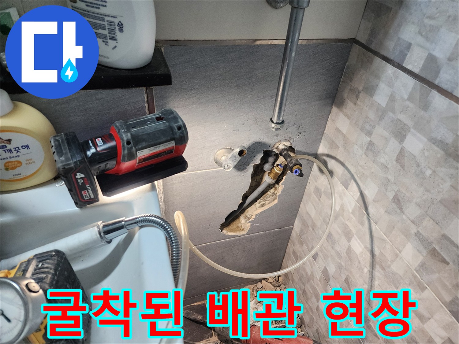 공사 중인 화장실 벽면의 노출된 배관과 장비