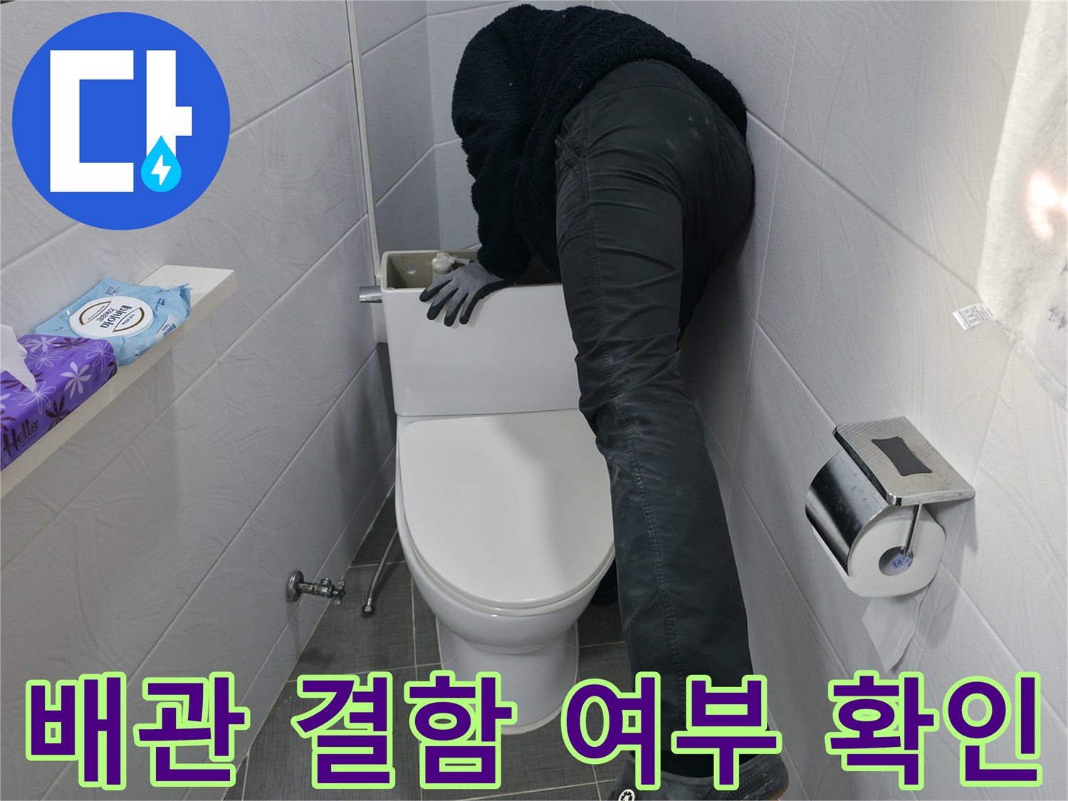 양변기 아래 노출된 하수 배관의 구조적 문제를 점검하는 엔지니어