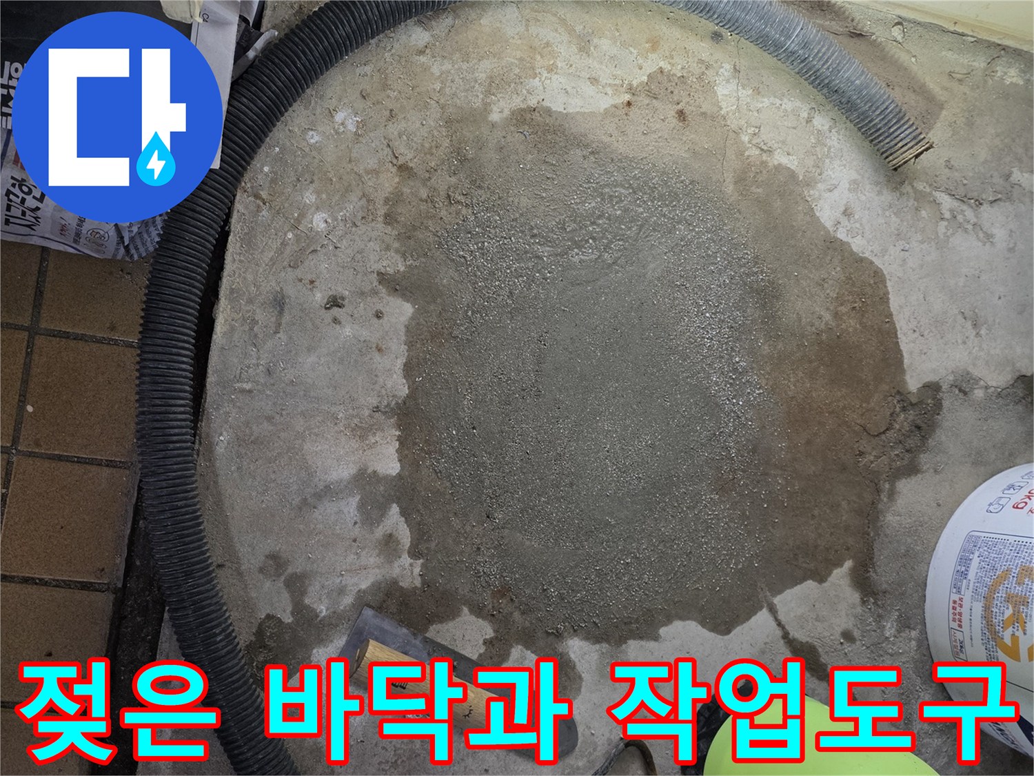 누수 공사 후 젖어 있는 바닥 면과 수동 작업 도구