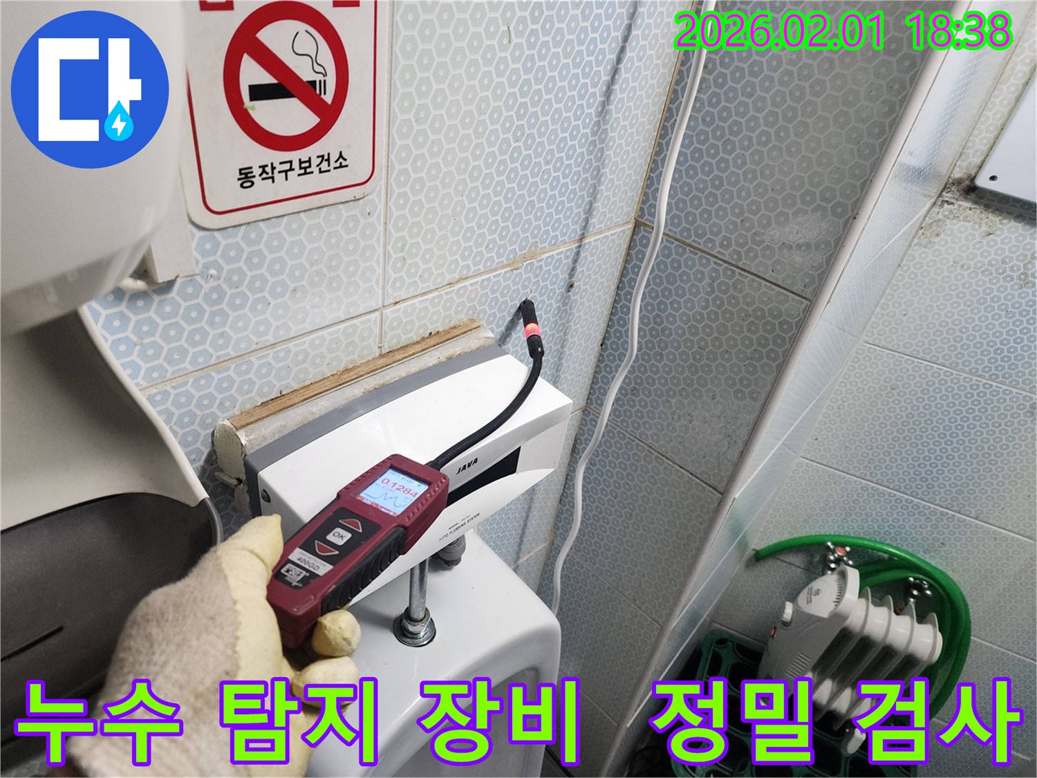 정밀 누수 탐지 장비를 사용하여 흑석동 건물 화장실의 누수 지점을 정확하게 찾아내는 모습입니다 - 누수 전문가의 숙련된 기술이 돋보입니다.