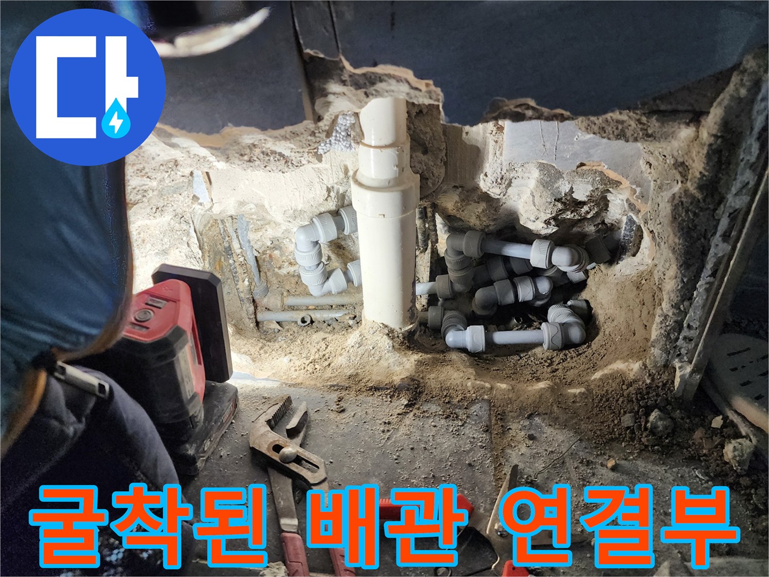 바닥을 파낸 뒤 나타난 변기 배관과 작업용 펜치