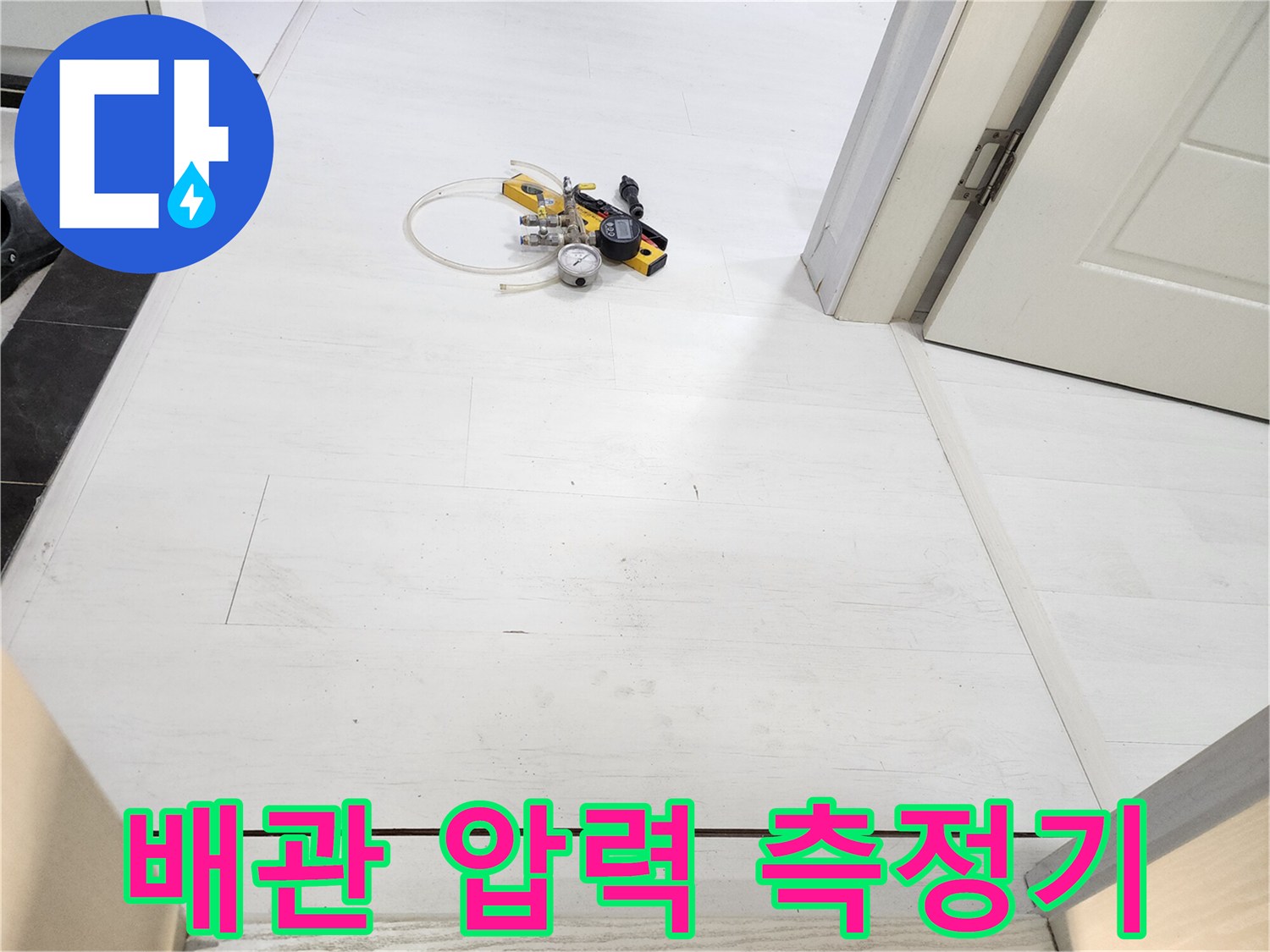 하얀색 타일 바닥 위 압력계와 연결 호스 세트