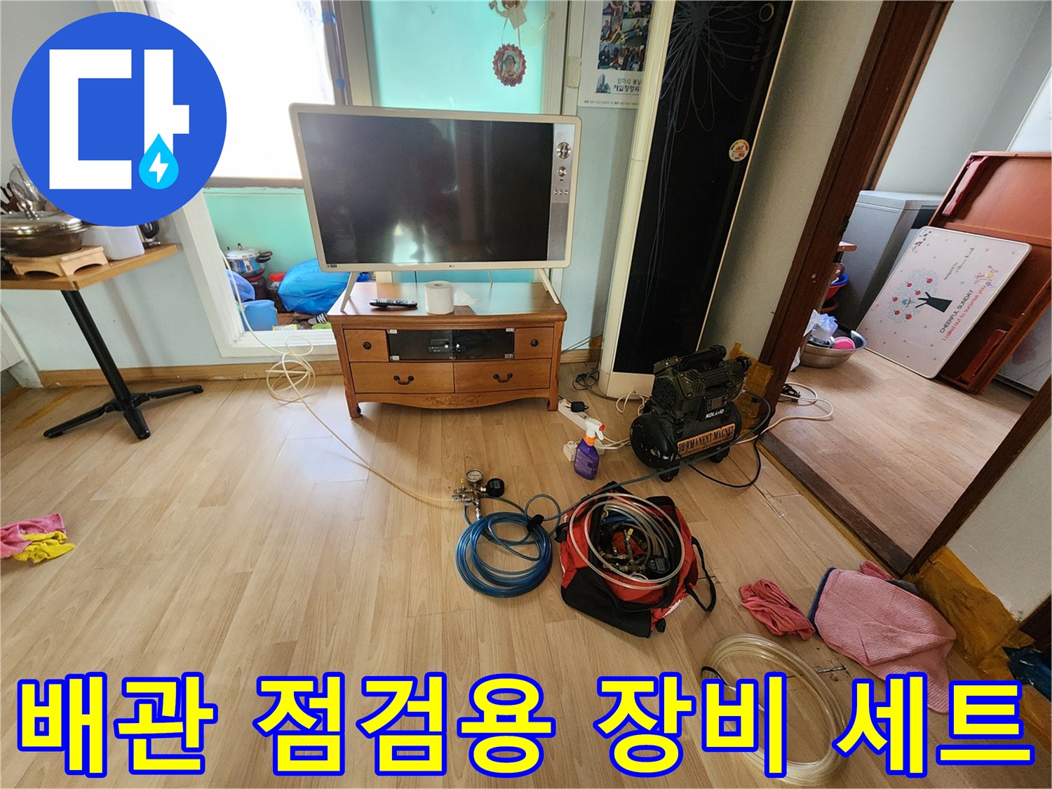 거실 바닥에 놓인 배관 검사용 가스 호스와 압력계