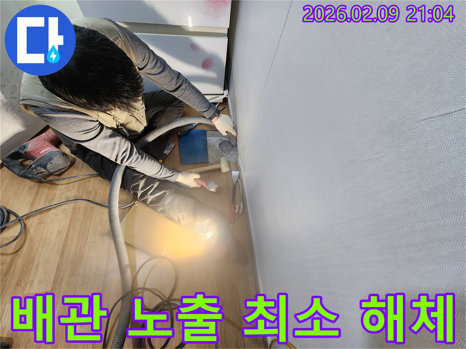 누수 전문 기술자가 배관을 노출시키기 위해 최소한의 범위만 정밀하게 해체하는 작업을 진행하고 있습니다.