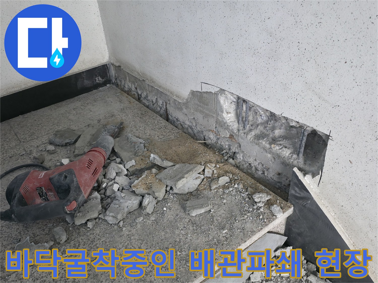 망치와 드릴을 사용하여 바닥 콘크리트를 파쇄하고 배관 위치를 노출하는 과정