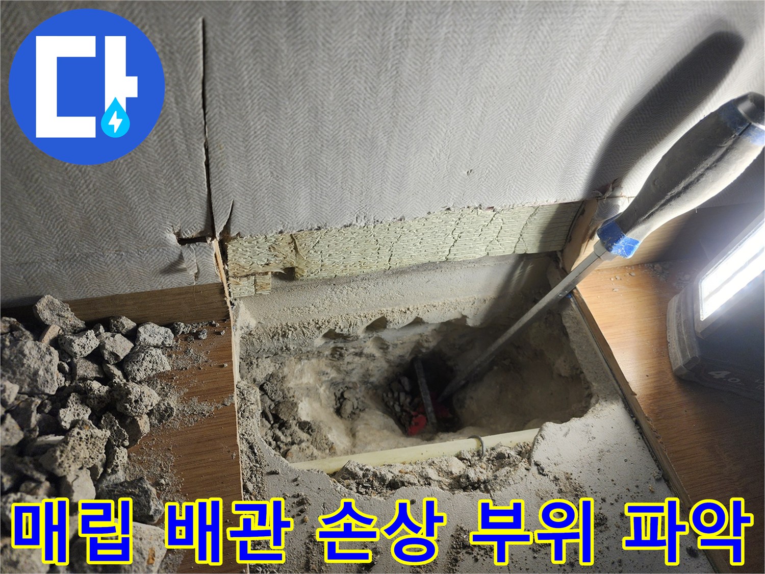 파쇄된 바닥 밑 노출된 회색 파이프와 현장 장비들