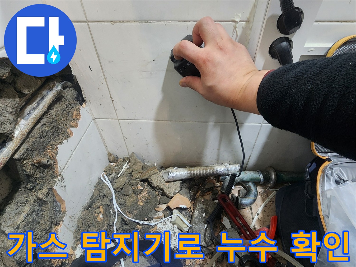 누수 지점 확인을 위해 가스식 탐지기를 벽면에 대고 있는 모습