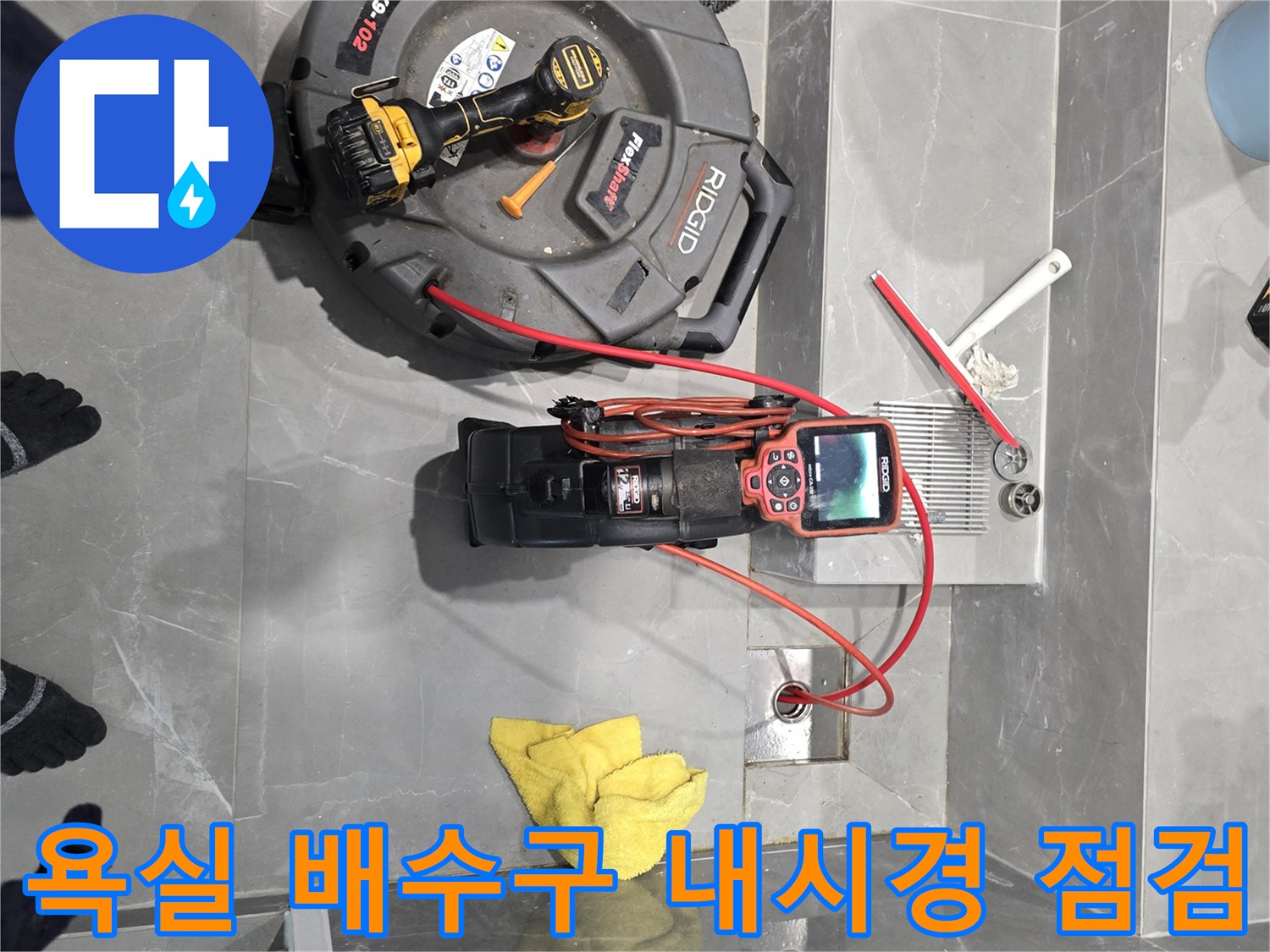 용인 수지구 욕실 바닥 배수구에 설치된 배관 내시경 카메라와 작업 장비들