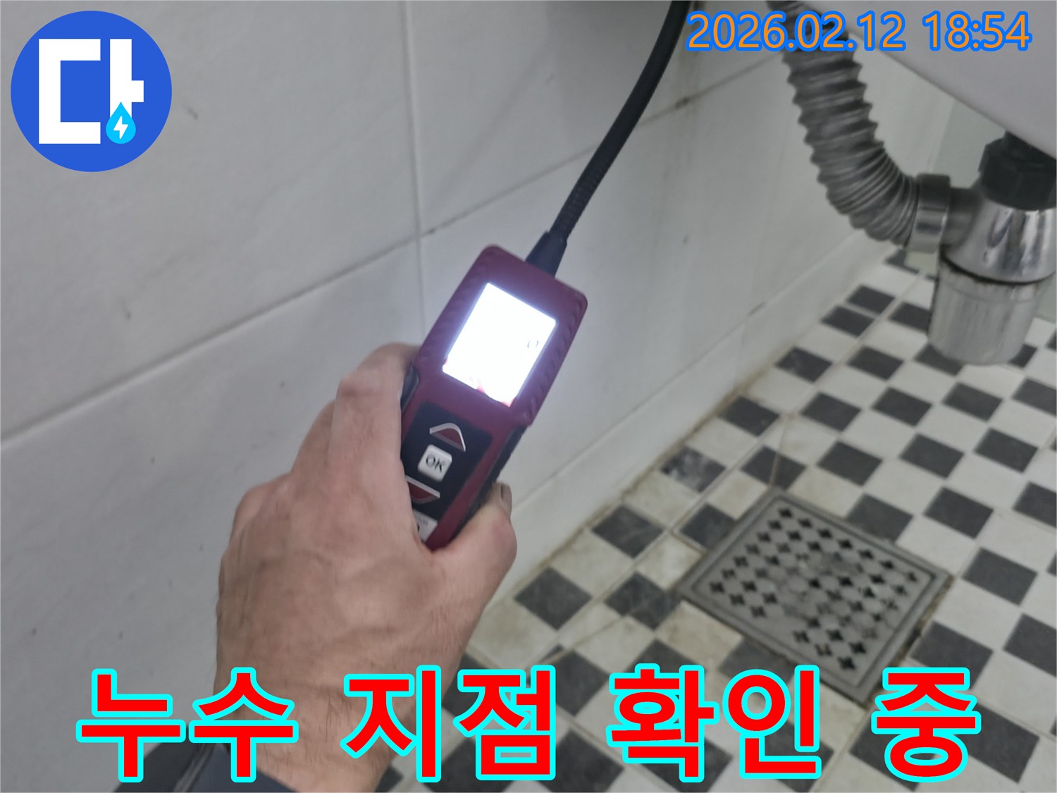 엔지니어가-고성능-누수-탐지기를-사용하여-화장실-배수구-근처의-미세한-누수-지점을-정확히-찾아내는-장면
