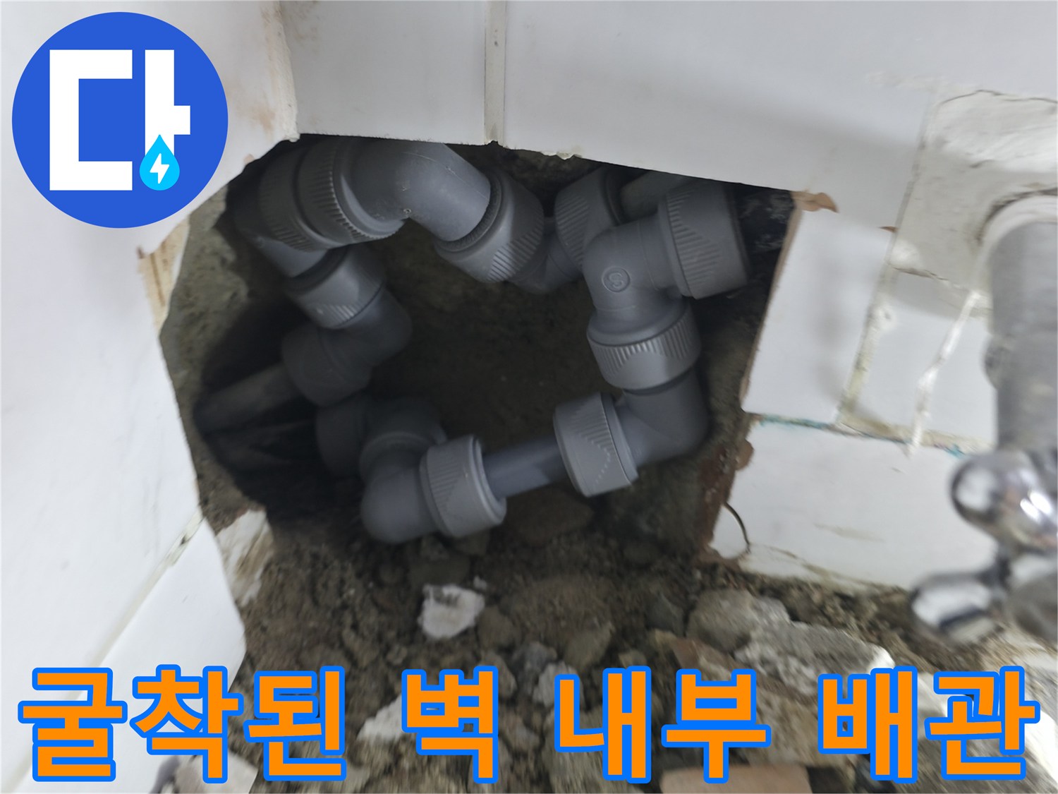 타일 제거 후 드러난 복잡한 형태의 회색 수도 부속 및 배관