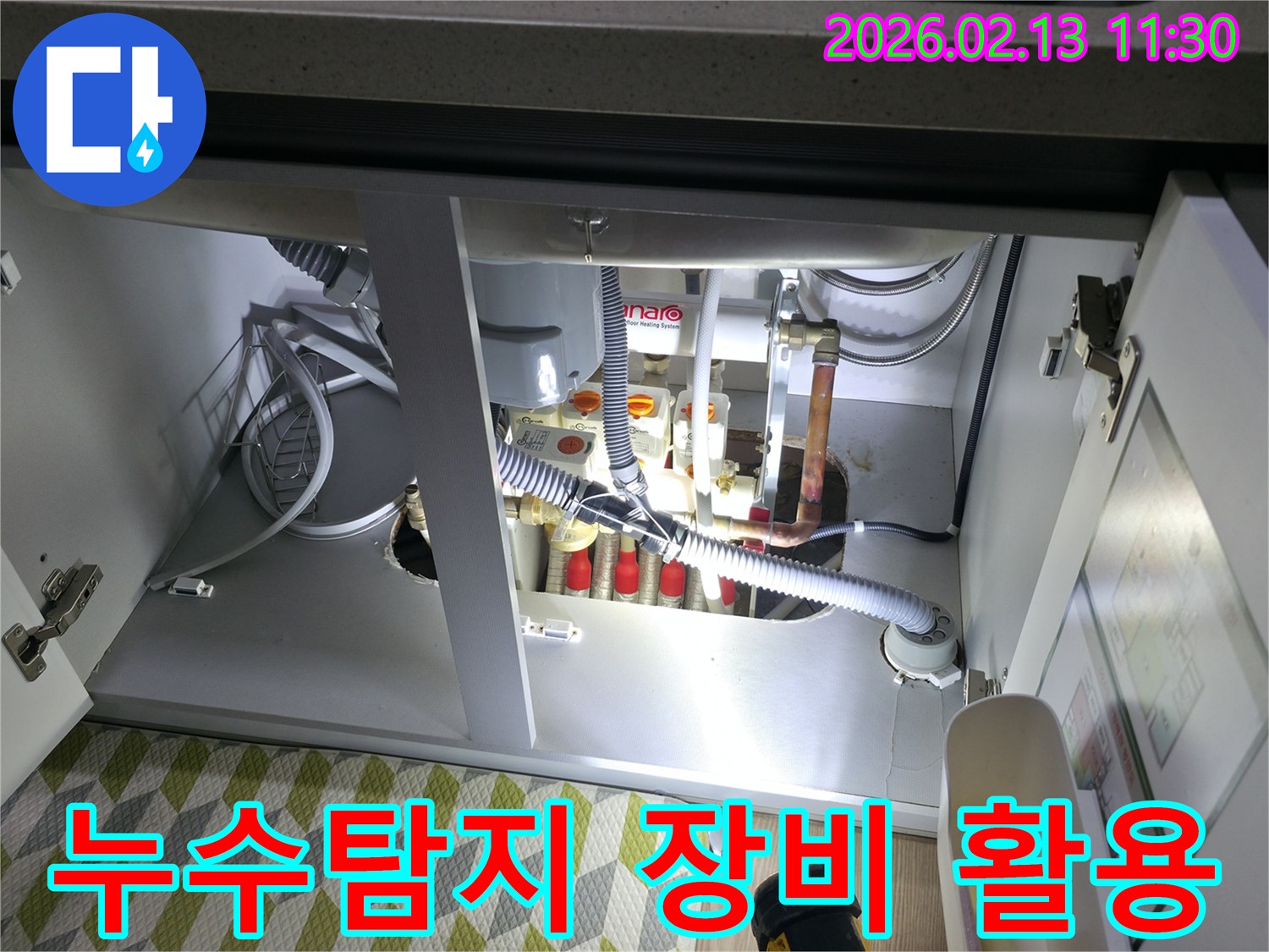 싱크대 하부의 미세한 누수 지점을-찾아내기 위해-전문가가 첨단 누수탐지 장비를-활용하는 모습