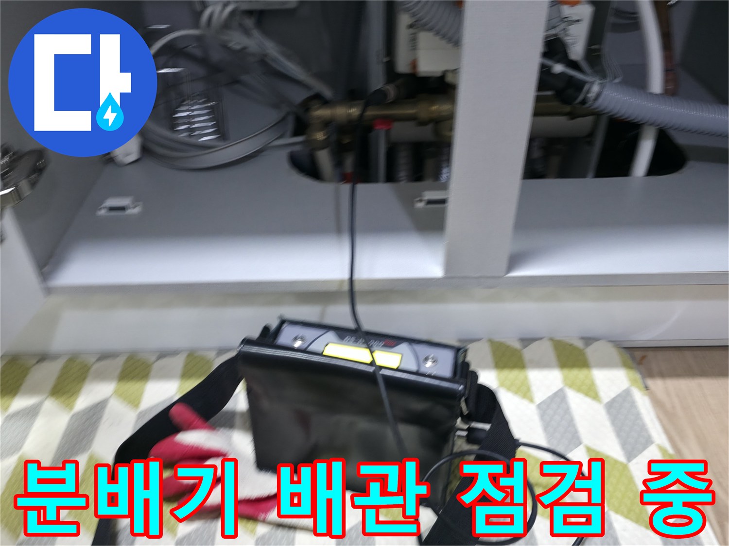 싱크대 하부장 내부의-난방 분배기 배관 검사 장면