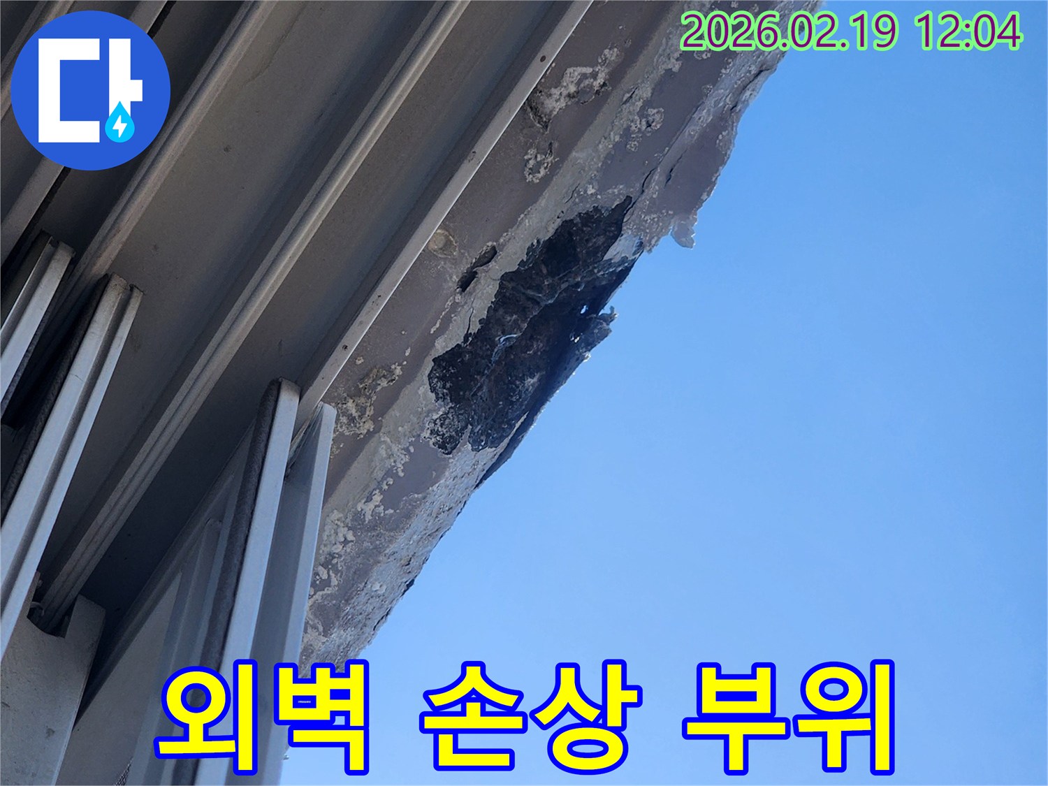 푸른 하늘을 배경으로-오래된 건물 외벽의-심각한 누수로 인한-표면 손상과 변색을 상세히 보여주는 사진
