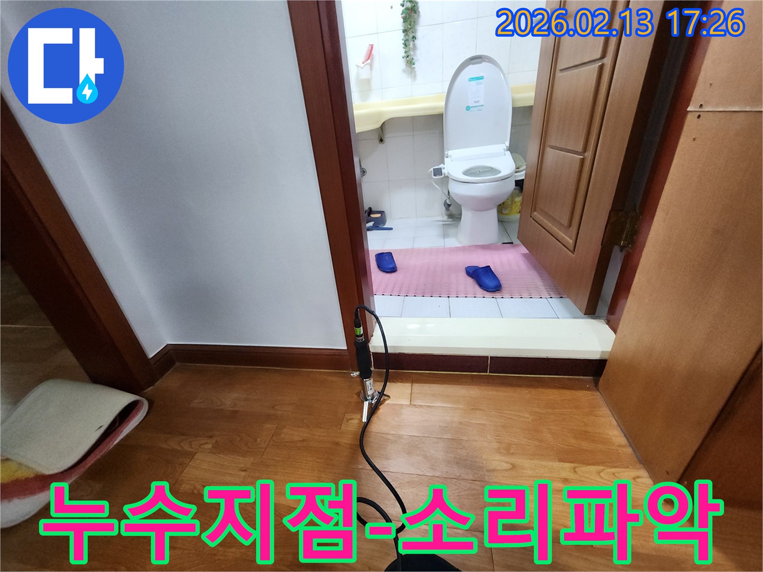 화장실 입구에 설치된 누수 탐지 장비로 미세한 소리를 통해 누수 지점을 정확히 파악하는 과정