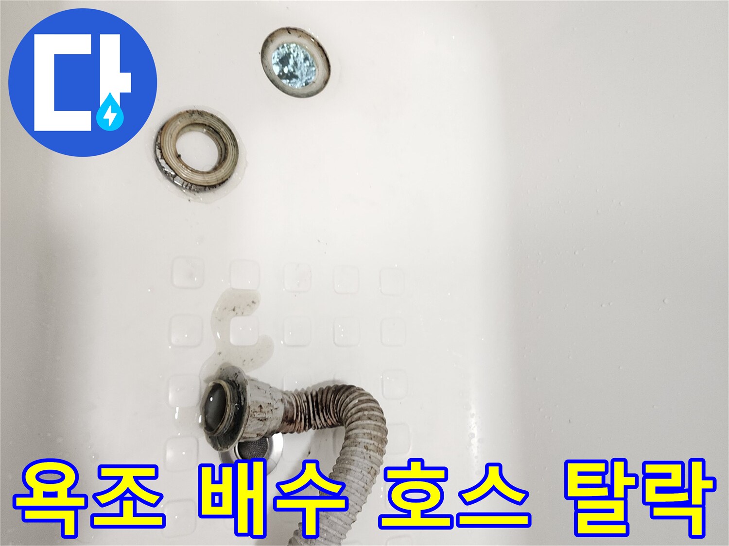 욕조 바닥에 놓인 훼손된 배수 트랩과 연결 호스