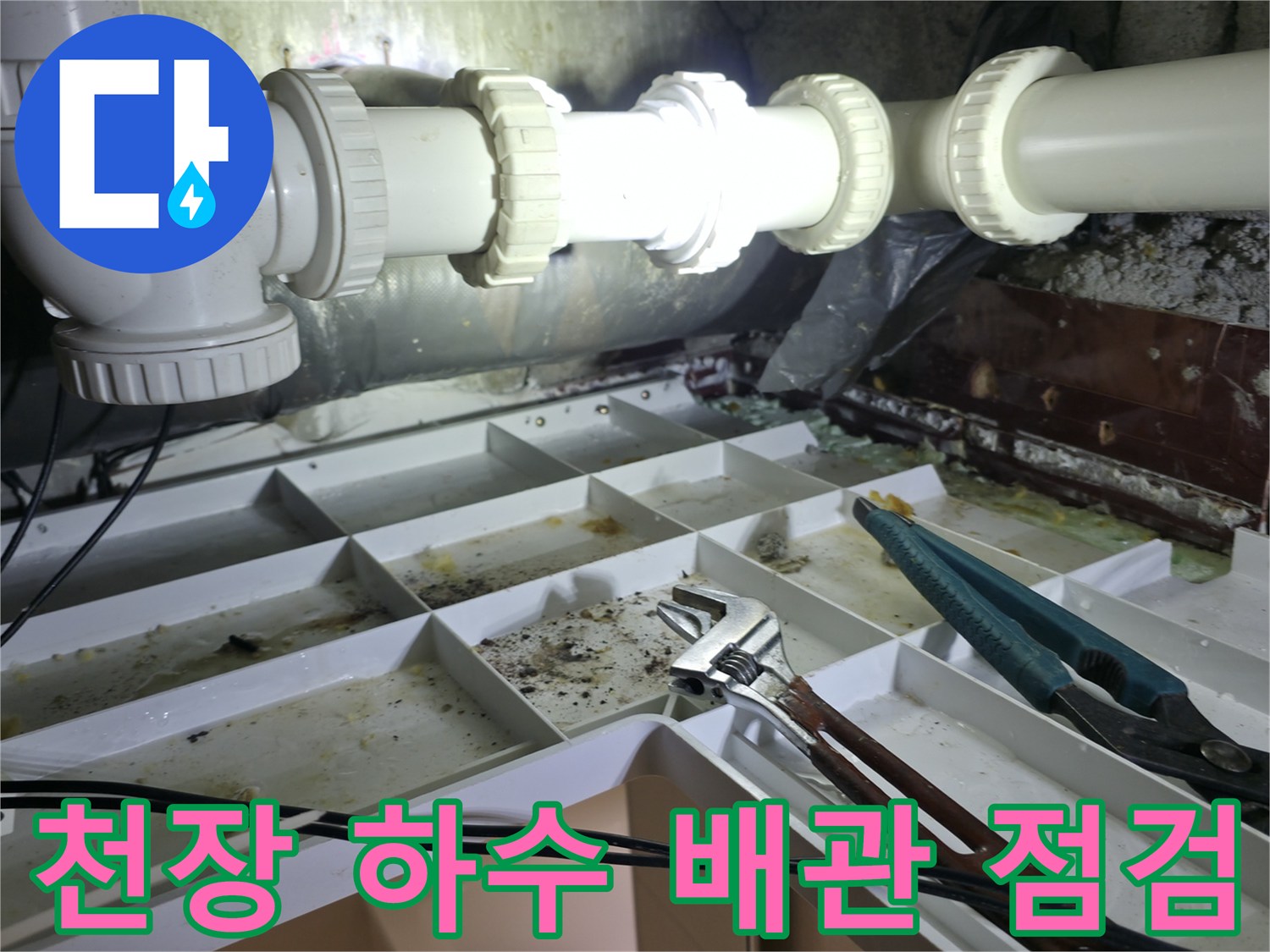 화장실 천장 내부의 노후된 PVC 배관과 공구류 배치 상태