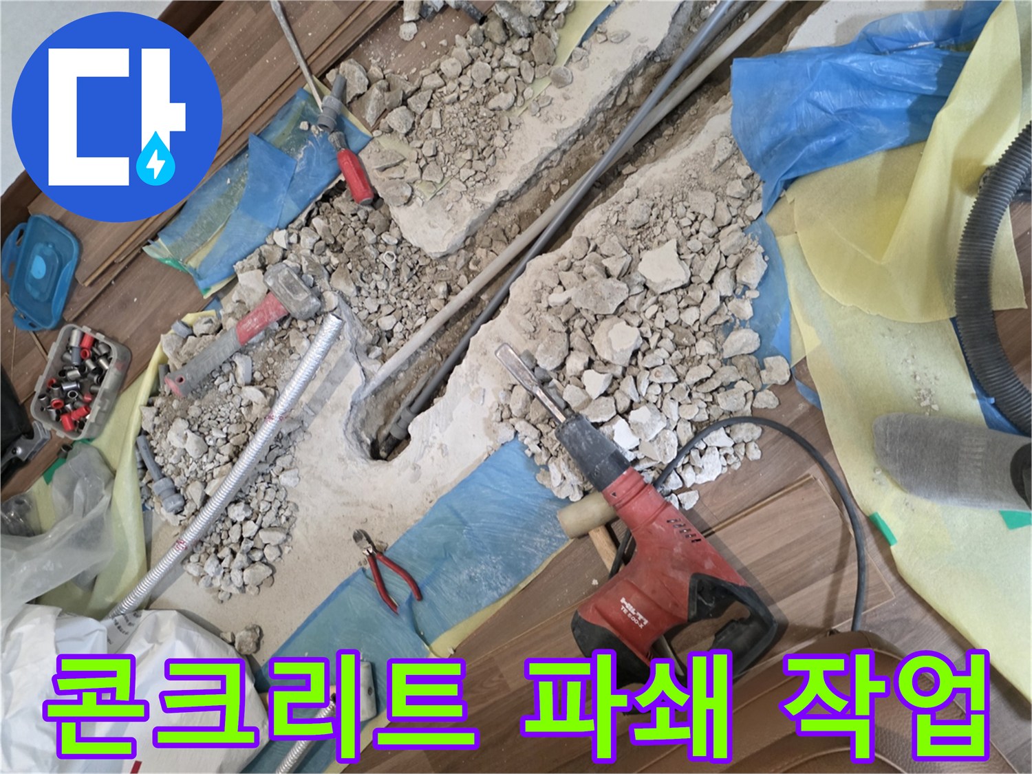 누수 지점을 찾기 위해 콘크리트 바닥을 굴착하고 있는 현장 사진입니다.