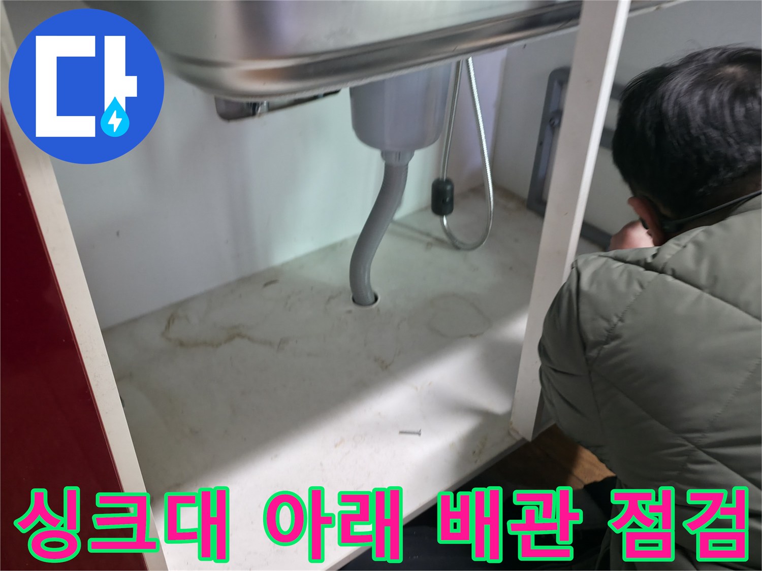 싱크대 밑 은색 주름관과 연결 부위의 누수 여부를 확인하는 과정