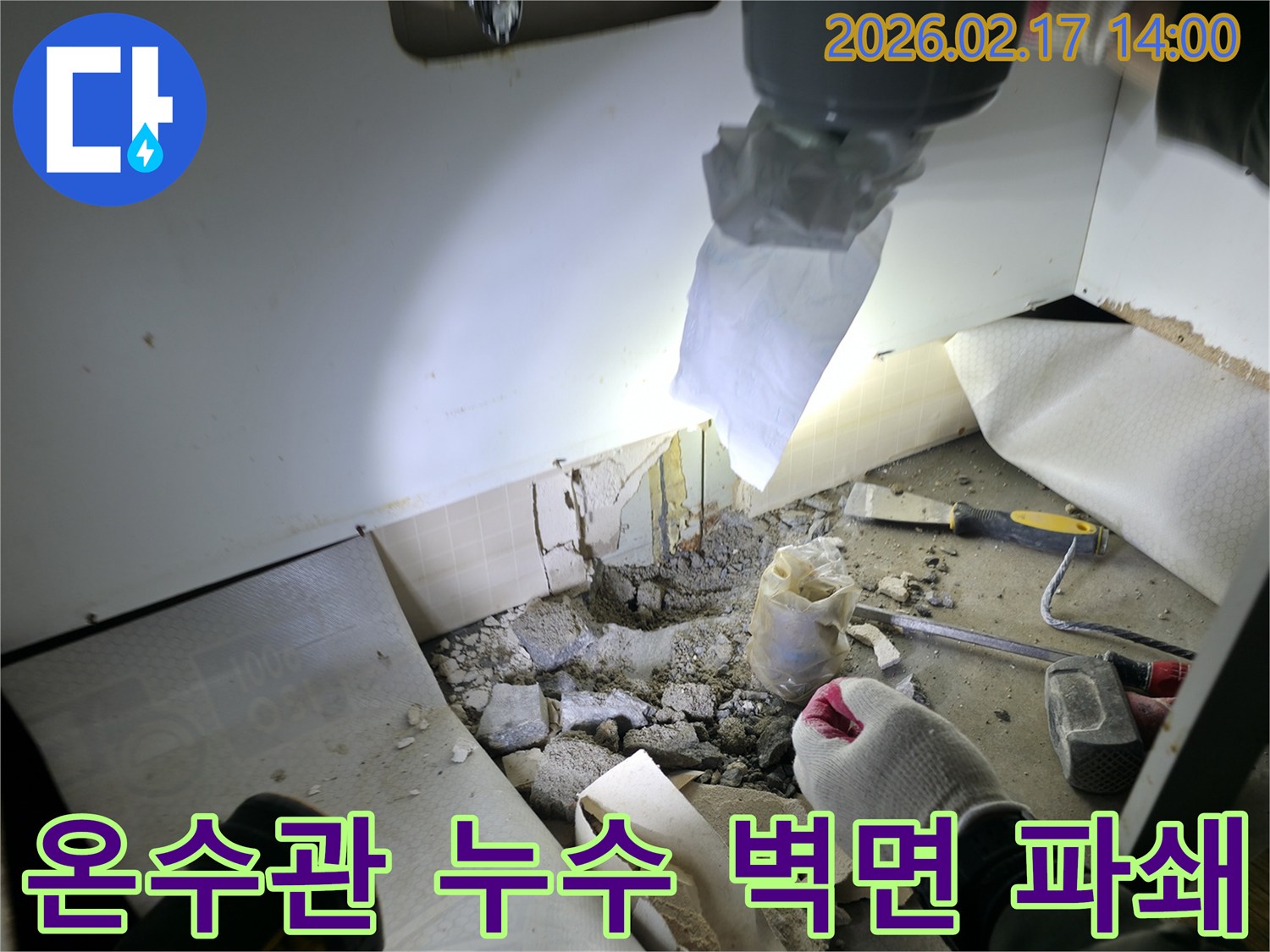 아파트 온수관 누수 현장에서-벽면을 파쇄하여-손상된 배관을 찾아내는 과정